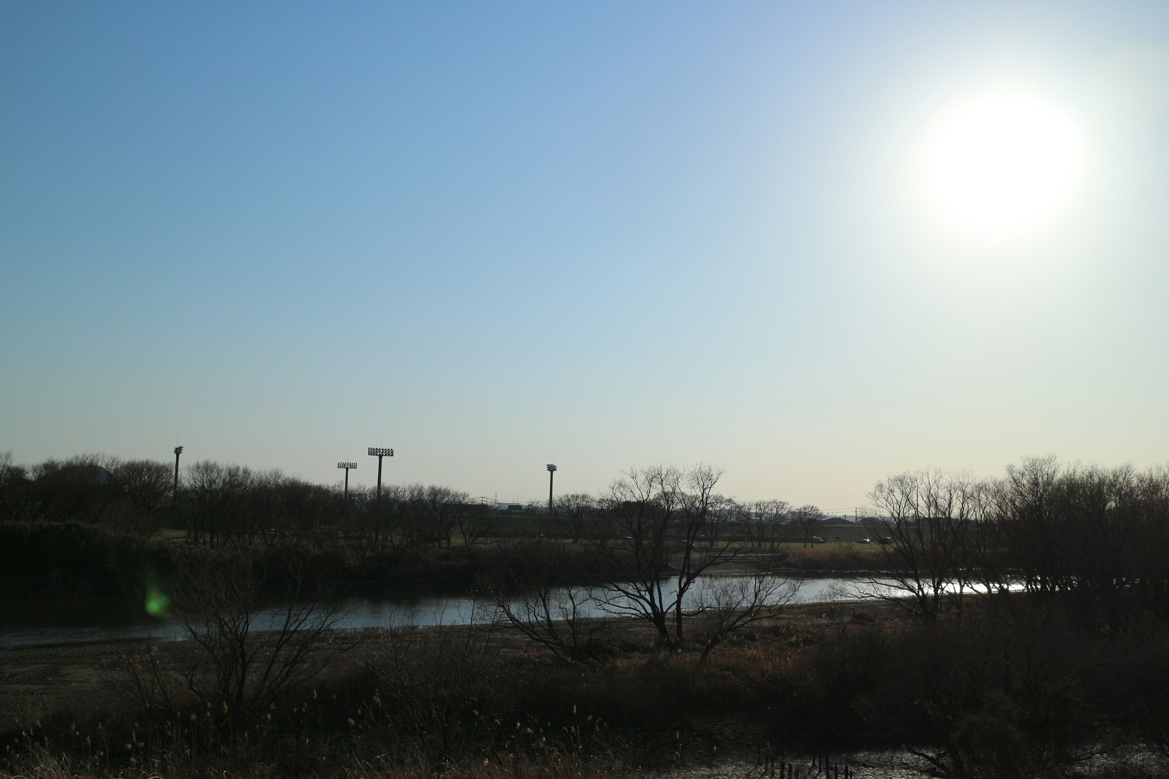 A serene river landscape under a clear blue sky