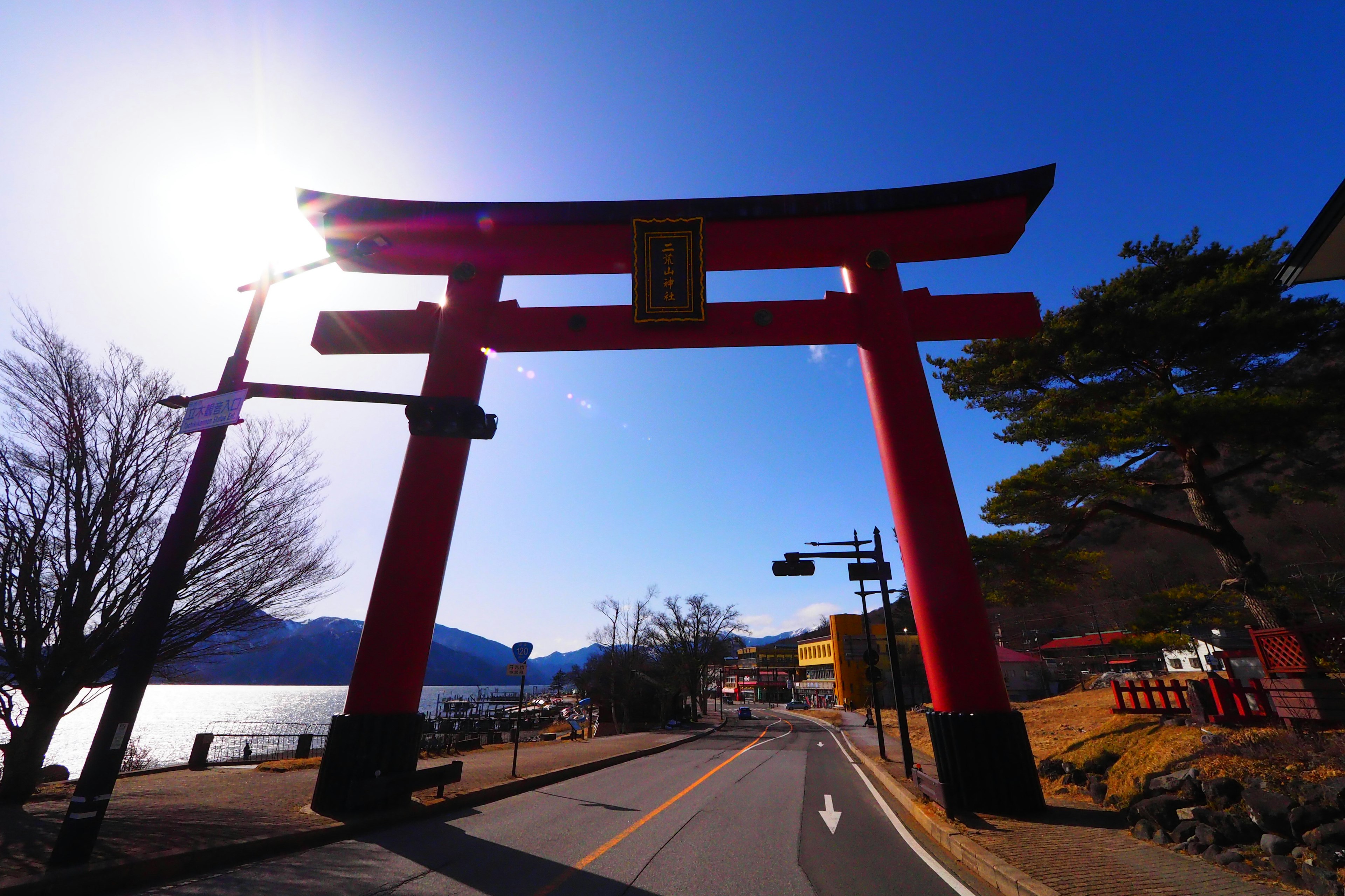 Gerbang torii merah dengan langit biru dan pemandangan danau