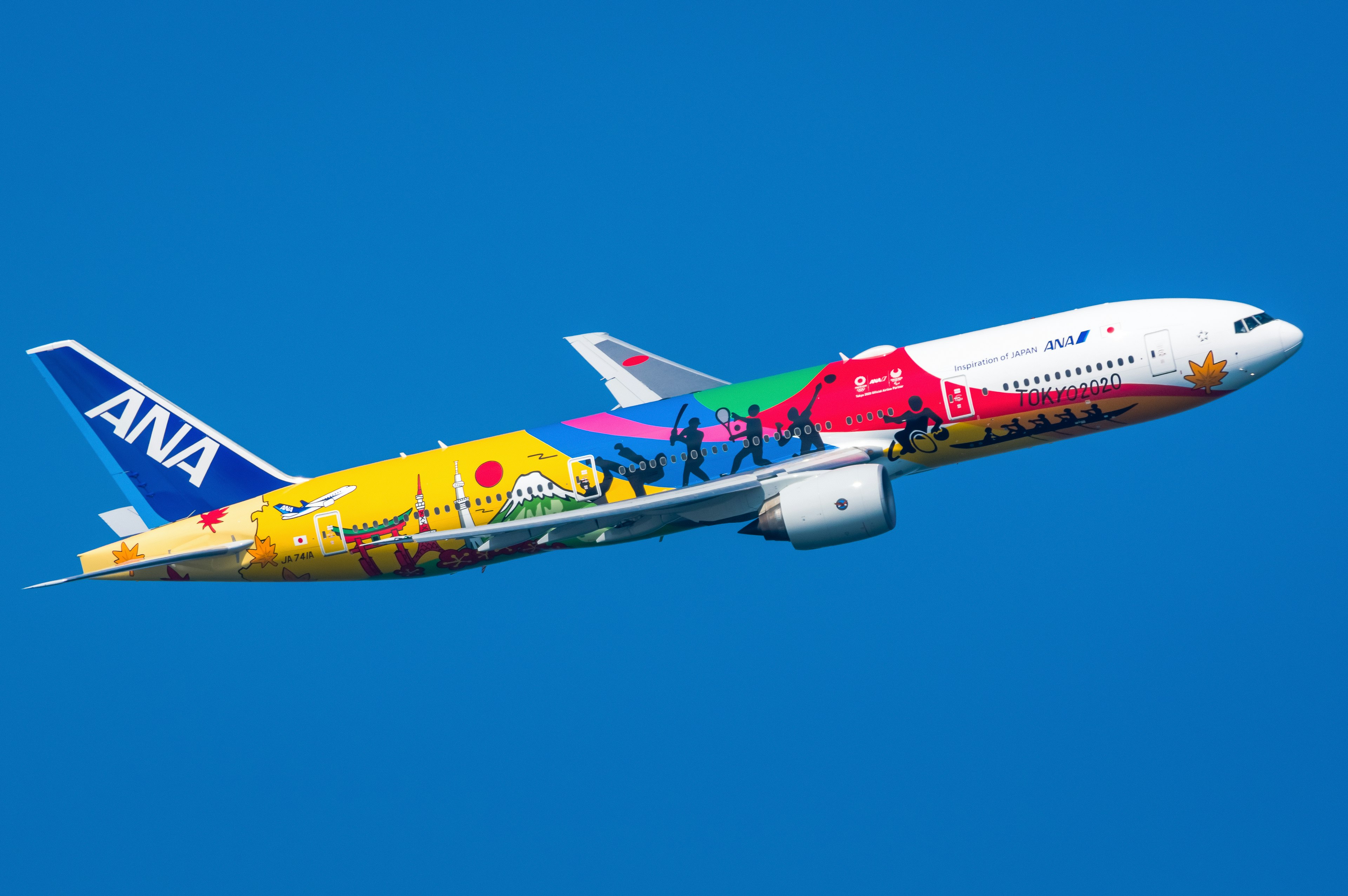 Colorful ANA airplane flying against a blue sky