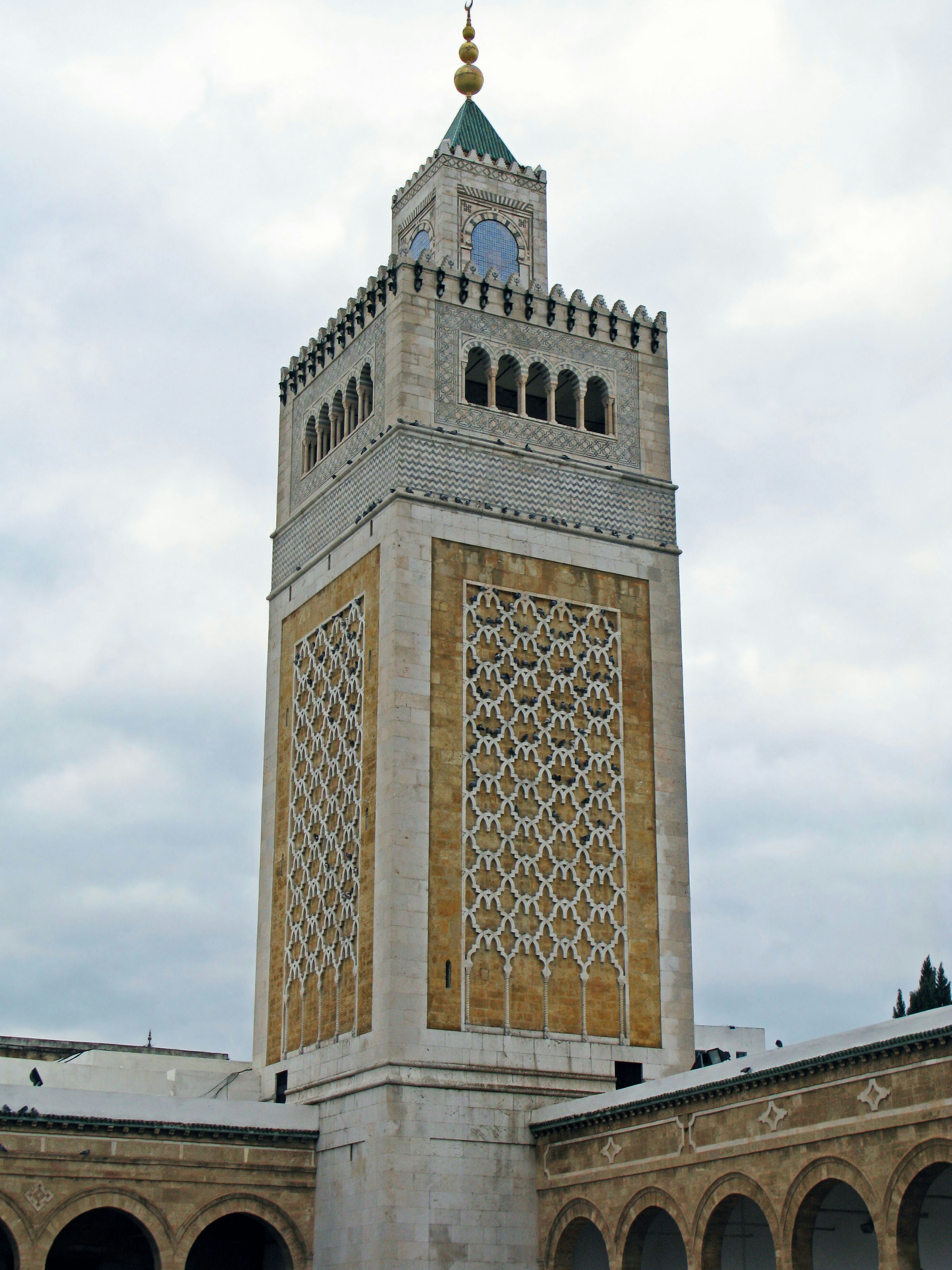 Schöner Minarett einer Moschee in Tunesien mit goldenen Verzierungen und geometrischen Mustern