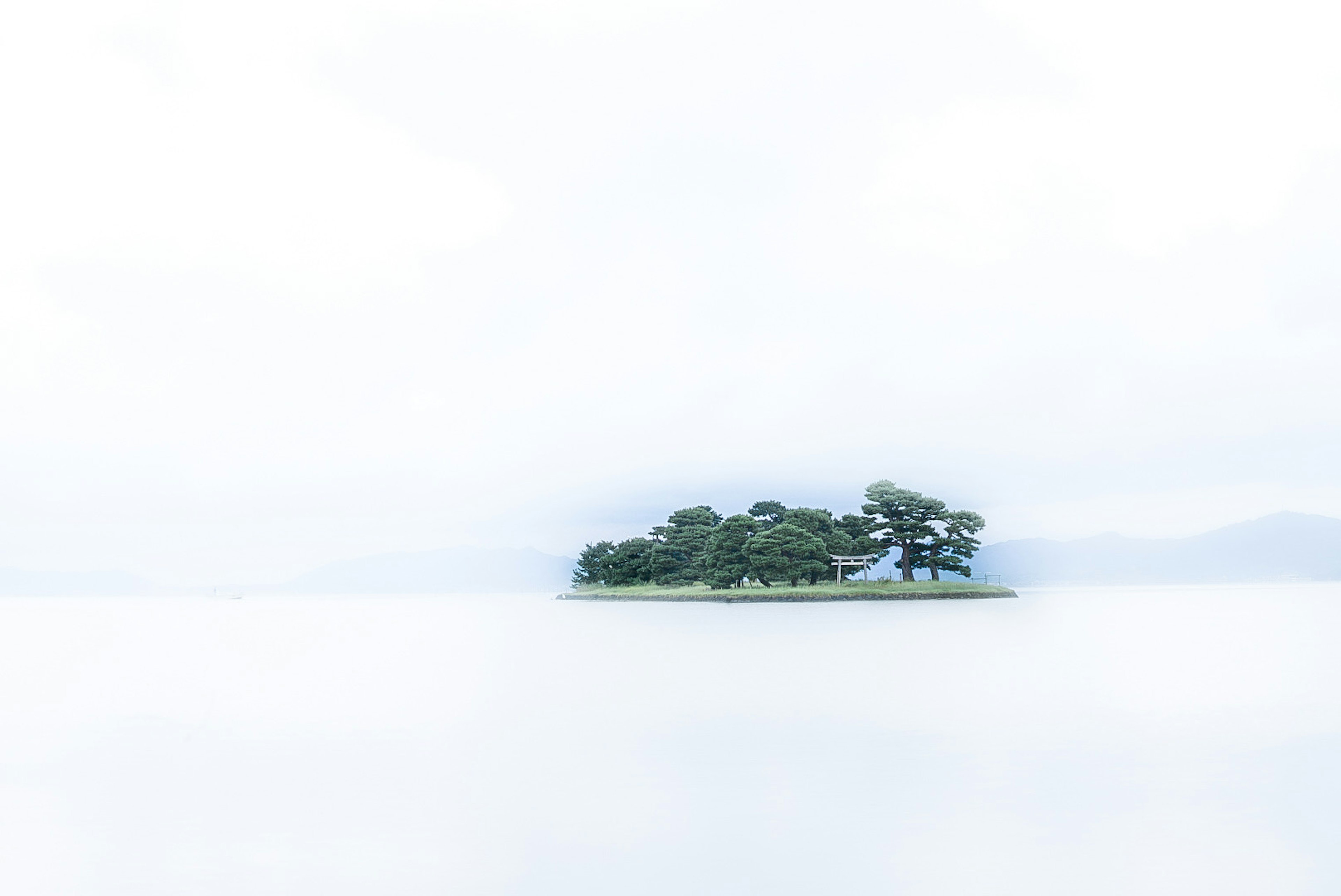 静かな湖の中に浮かぶ小さな島と緑の木々