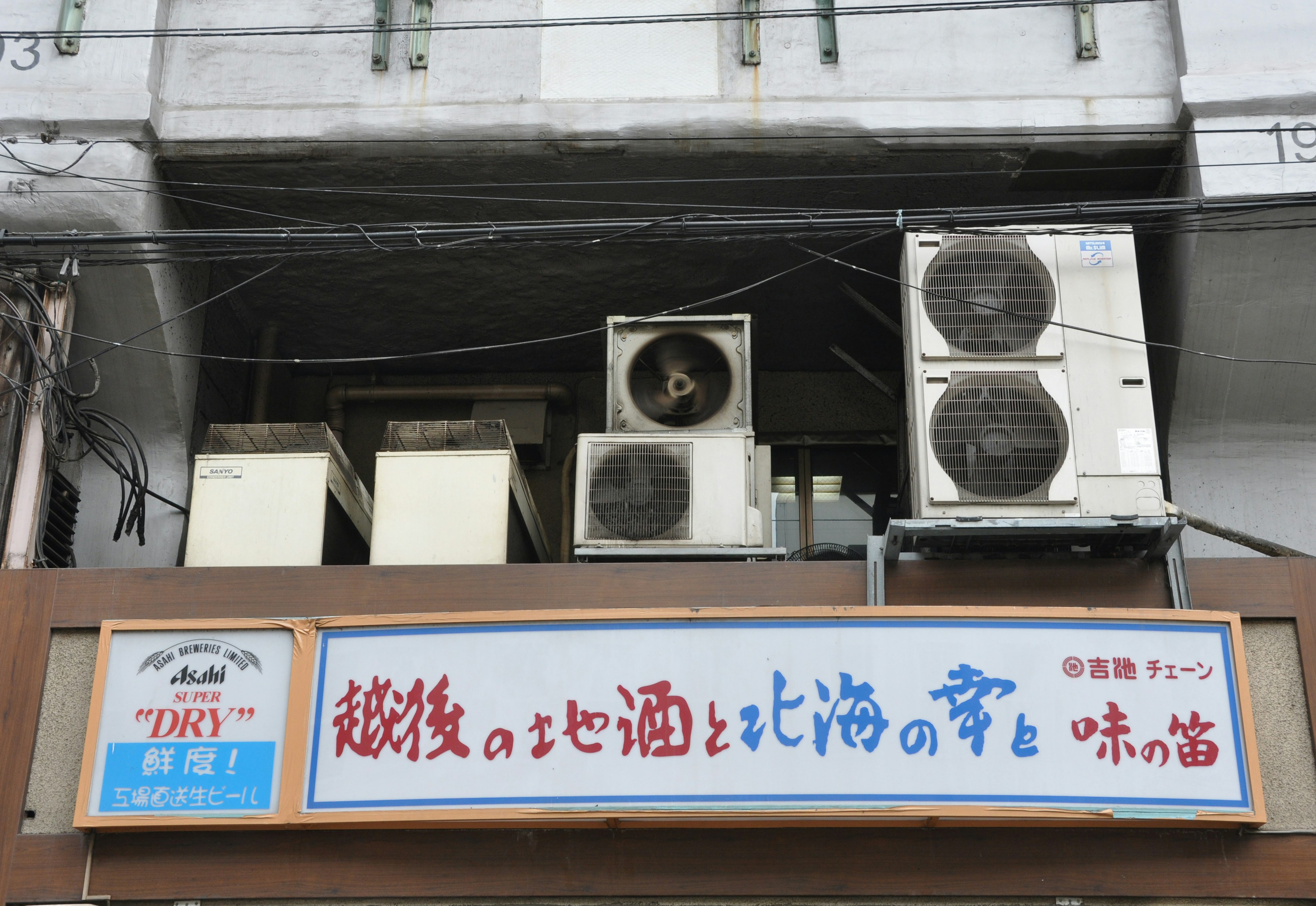 Exterior de un restaurante con un letrero y unidades de aire acondicionado