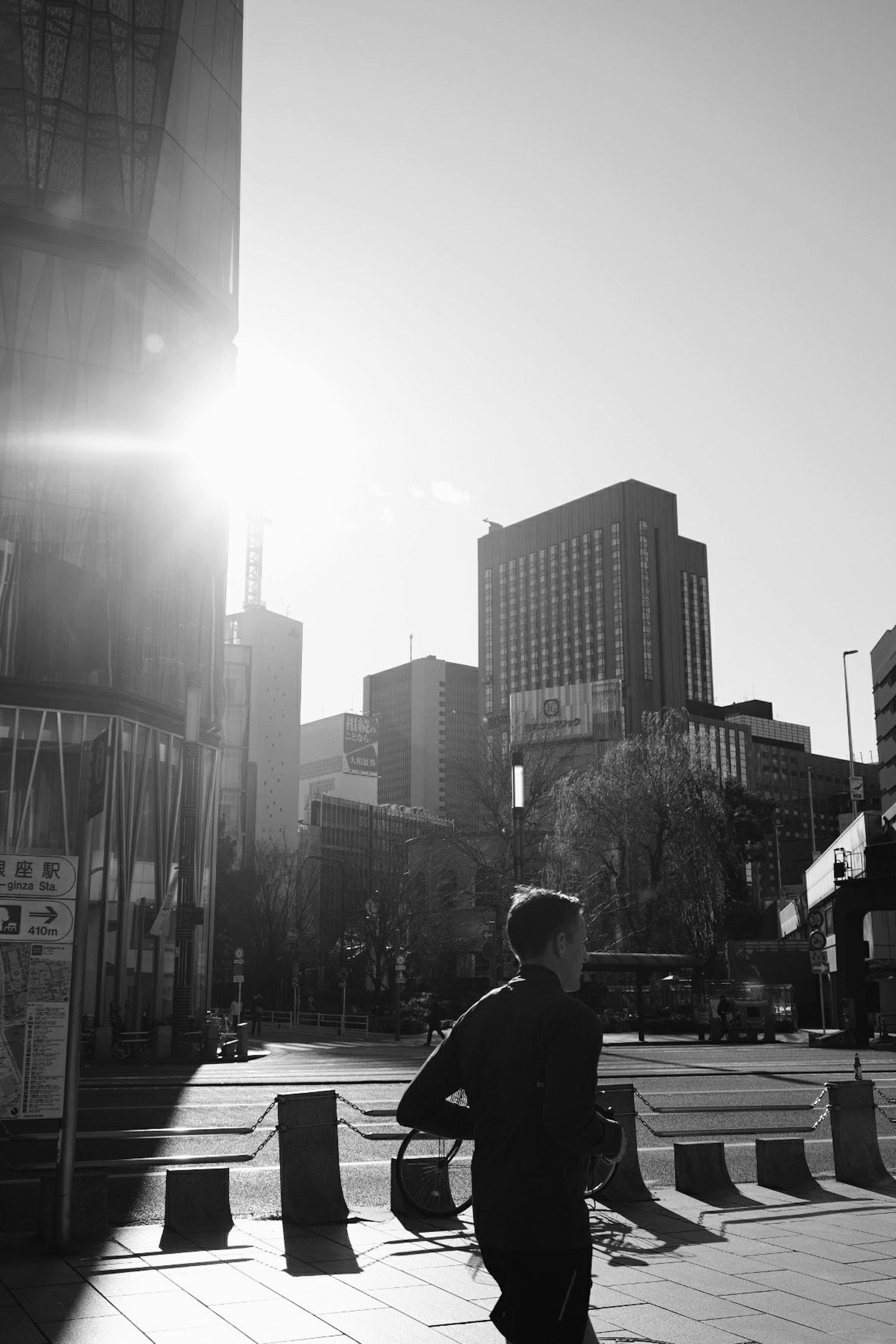 A person running in a black and white cityscape with tall buildings in the background