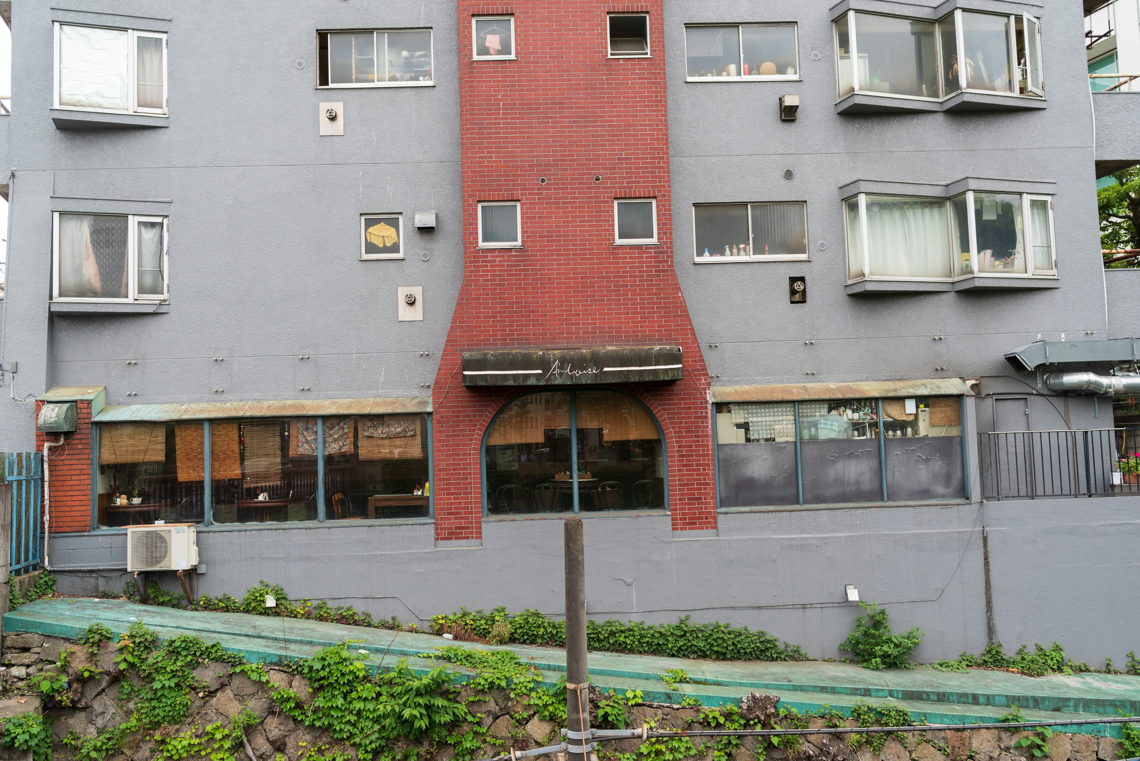 Bâtiment gris avec une entrée rouge distinctive