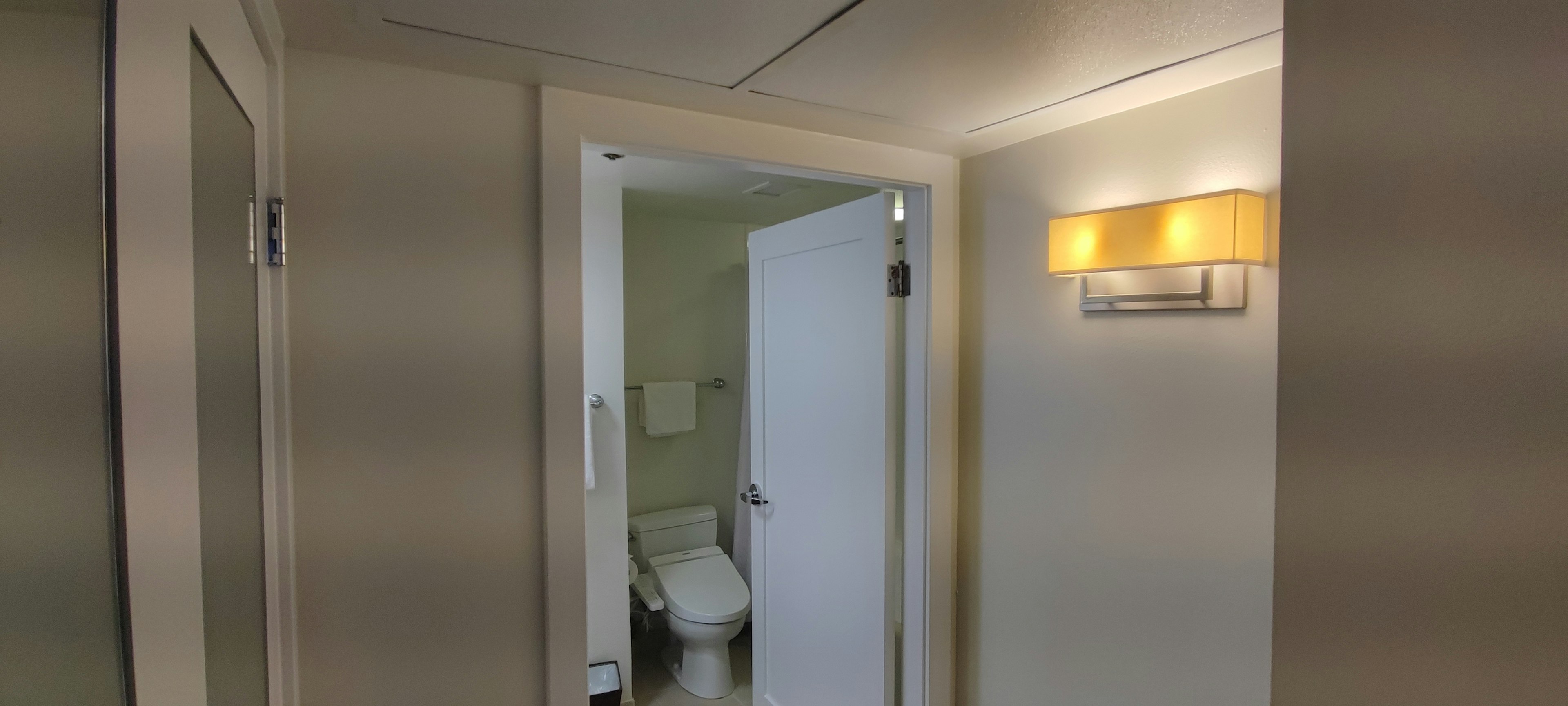 Couloir lumineux avec une porte de salle de bain visible