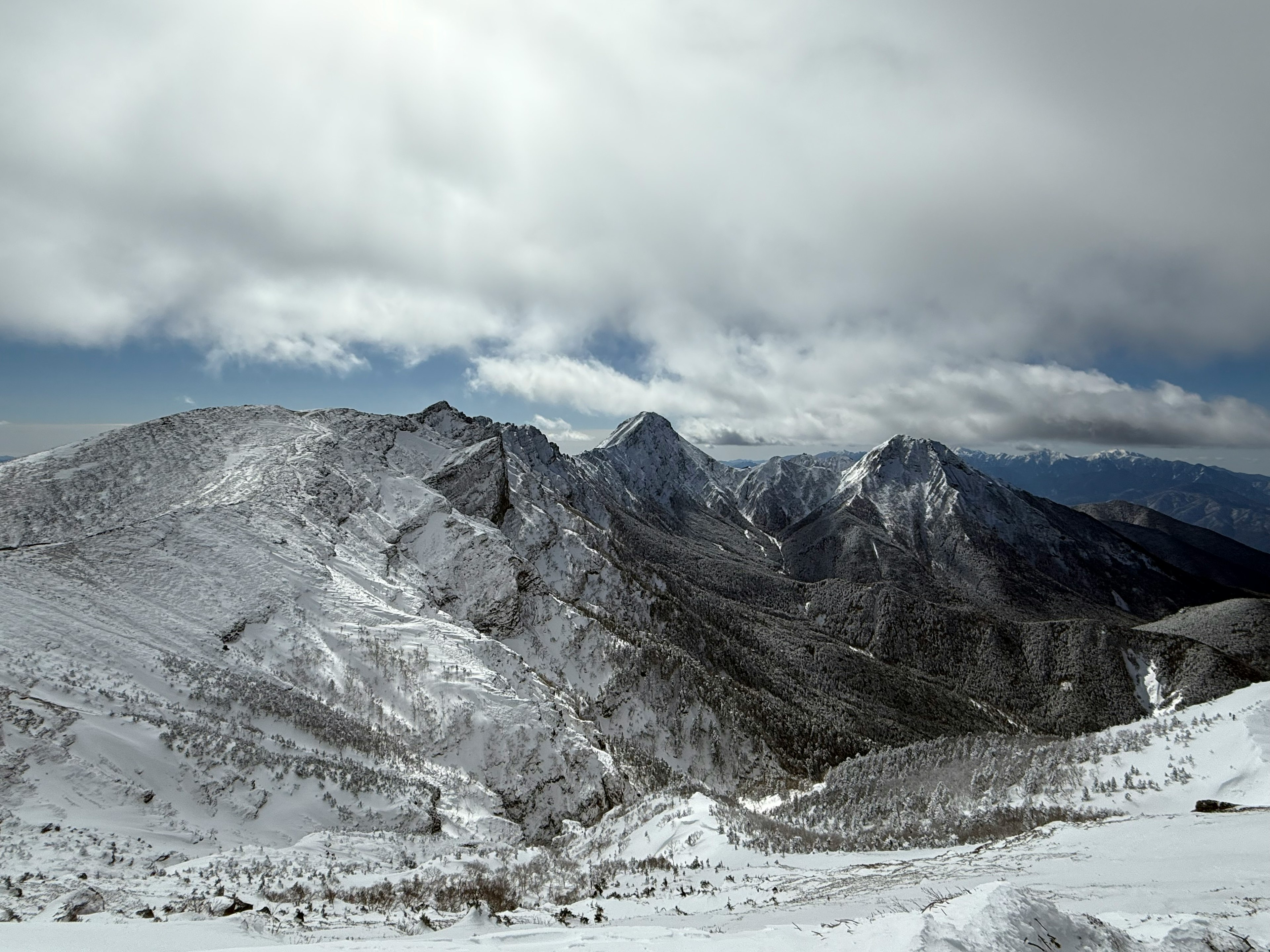 雪覆蓋的山脈在陰雲的天空下