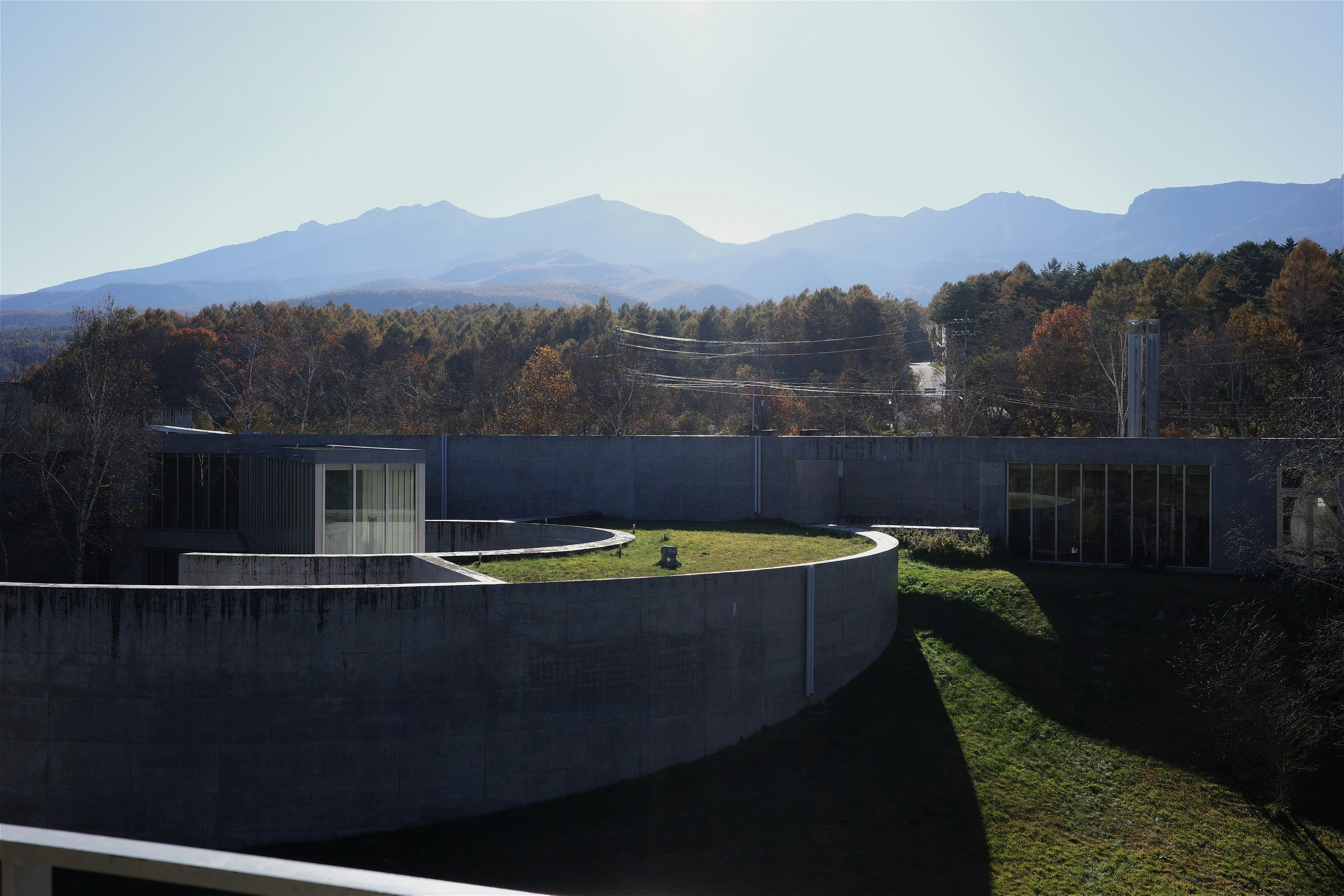 現代建築與綠色屋頂，背景為山脈