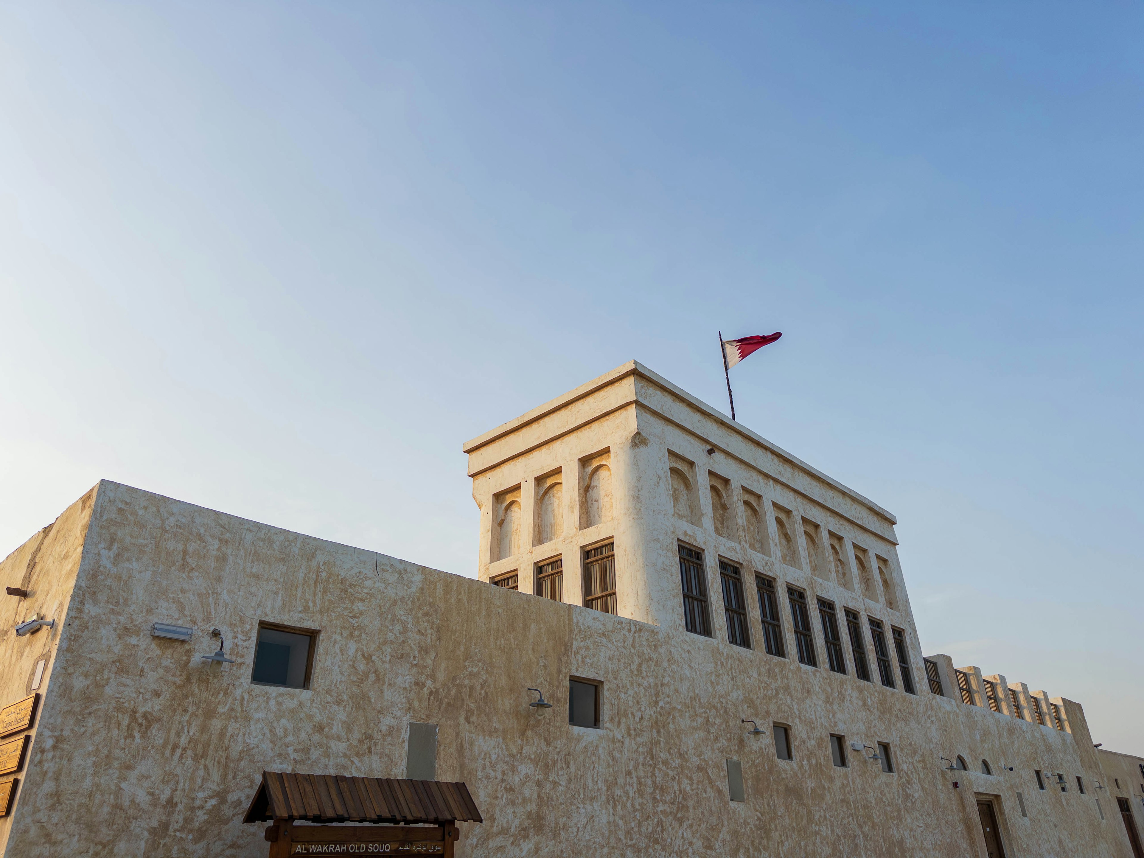 Historical building exterior with a flag and blue sky