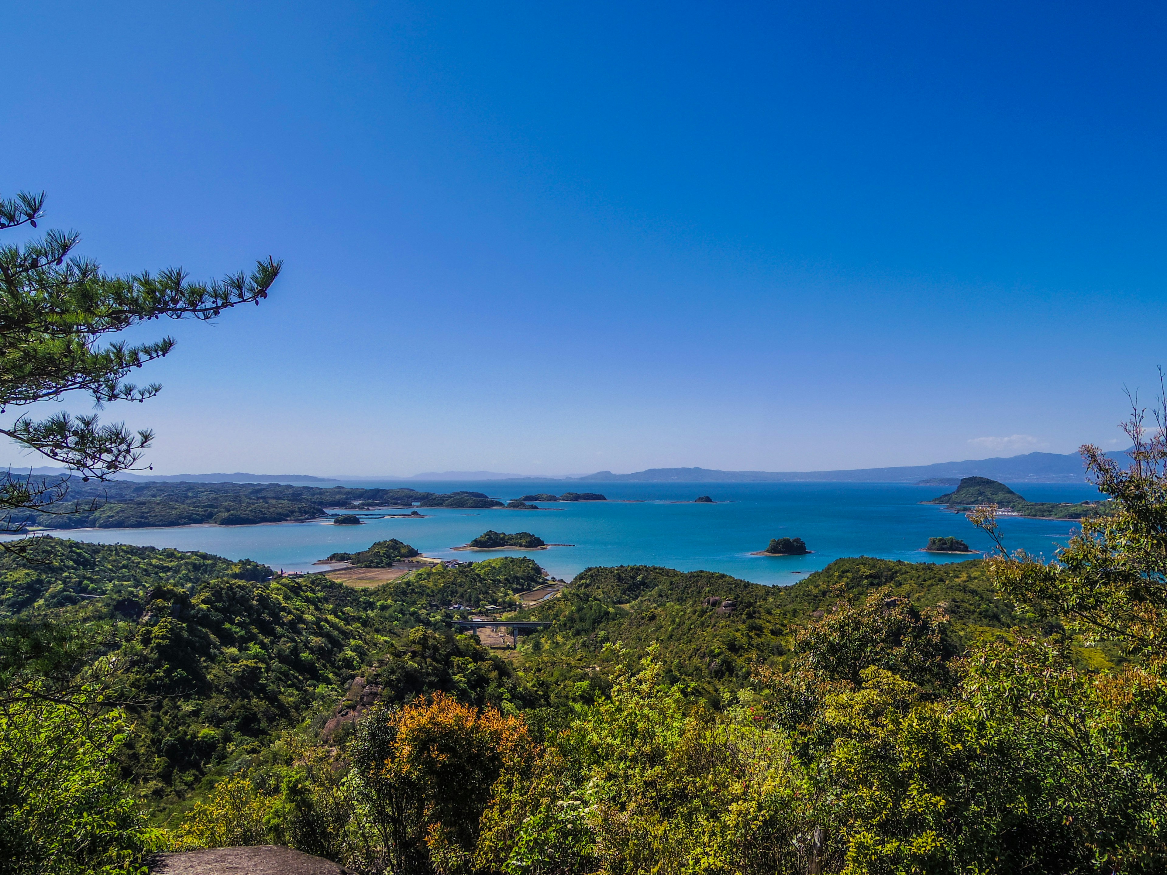 Malersiche Aussicht auf einen blauen Himmel und ein schönes Meer umgeben von üppigem Grün und einer Bucht