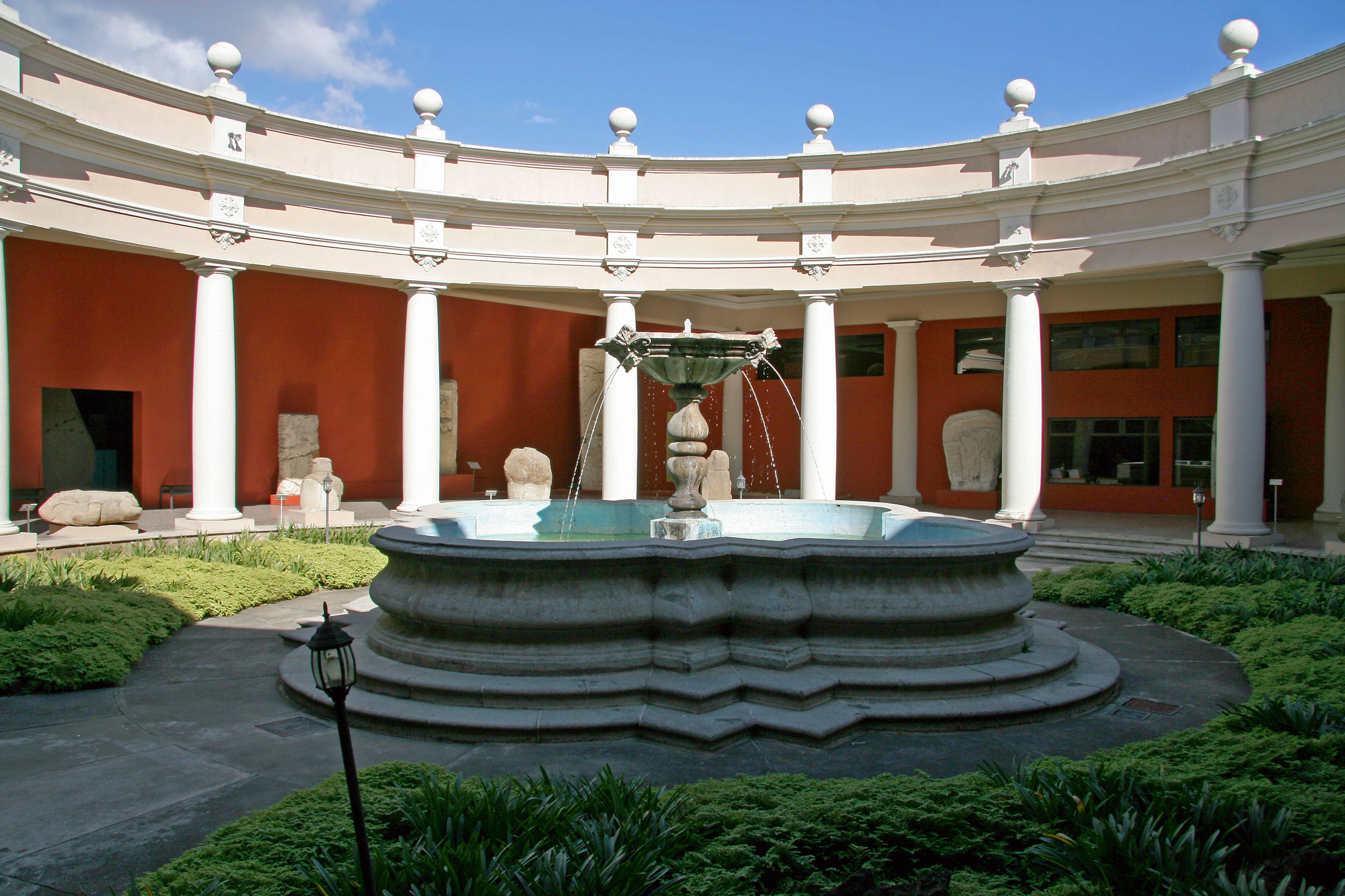 Belle fontaine dans un jardin circulaire avec des colonnes entourant l'espace