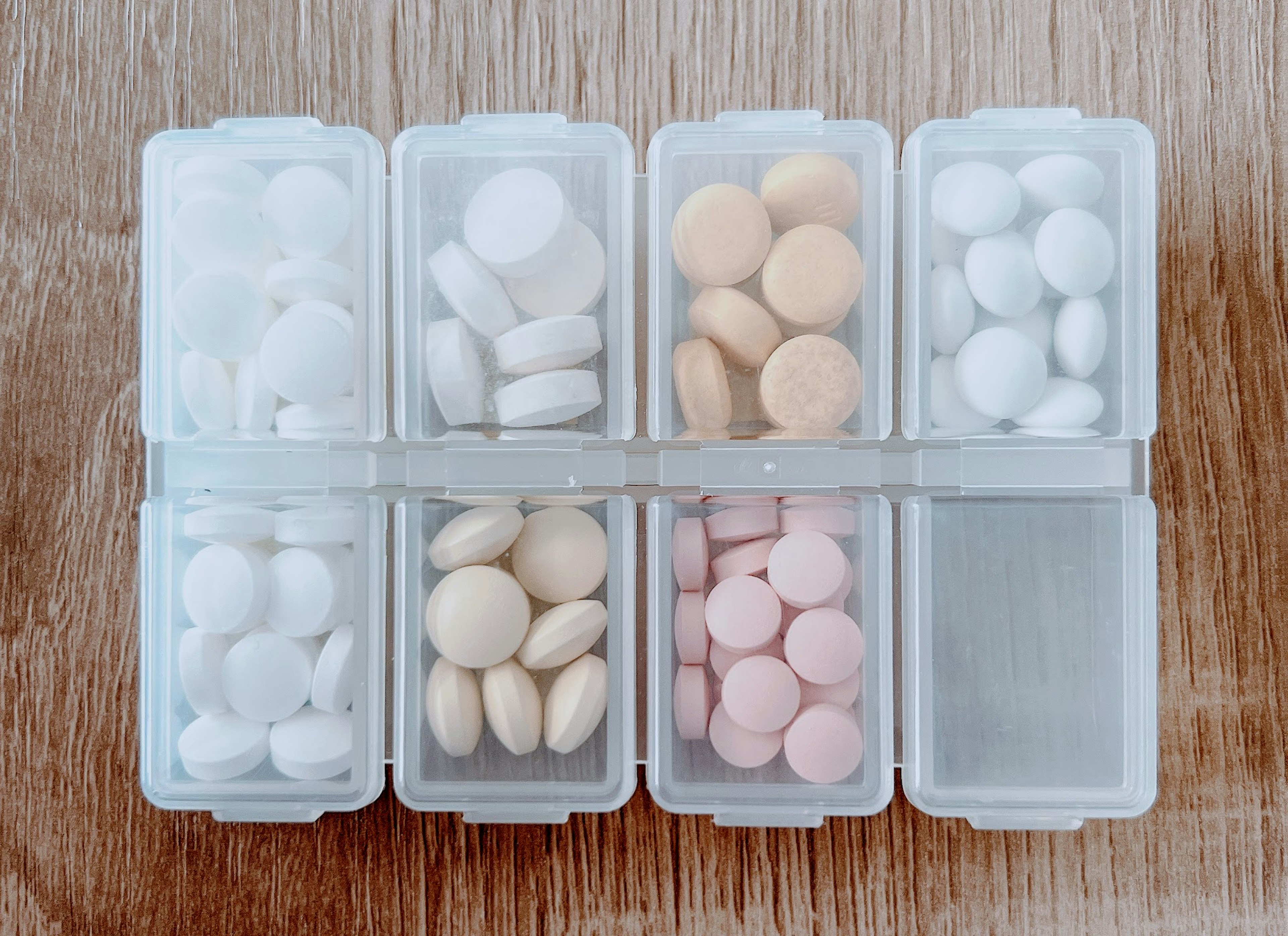 Organized assortment of white and pink pills in a transparent pill organizer