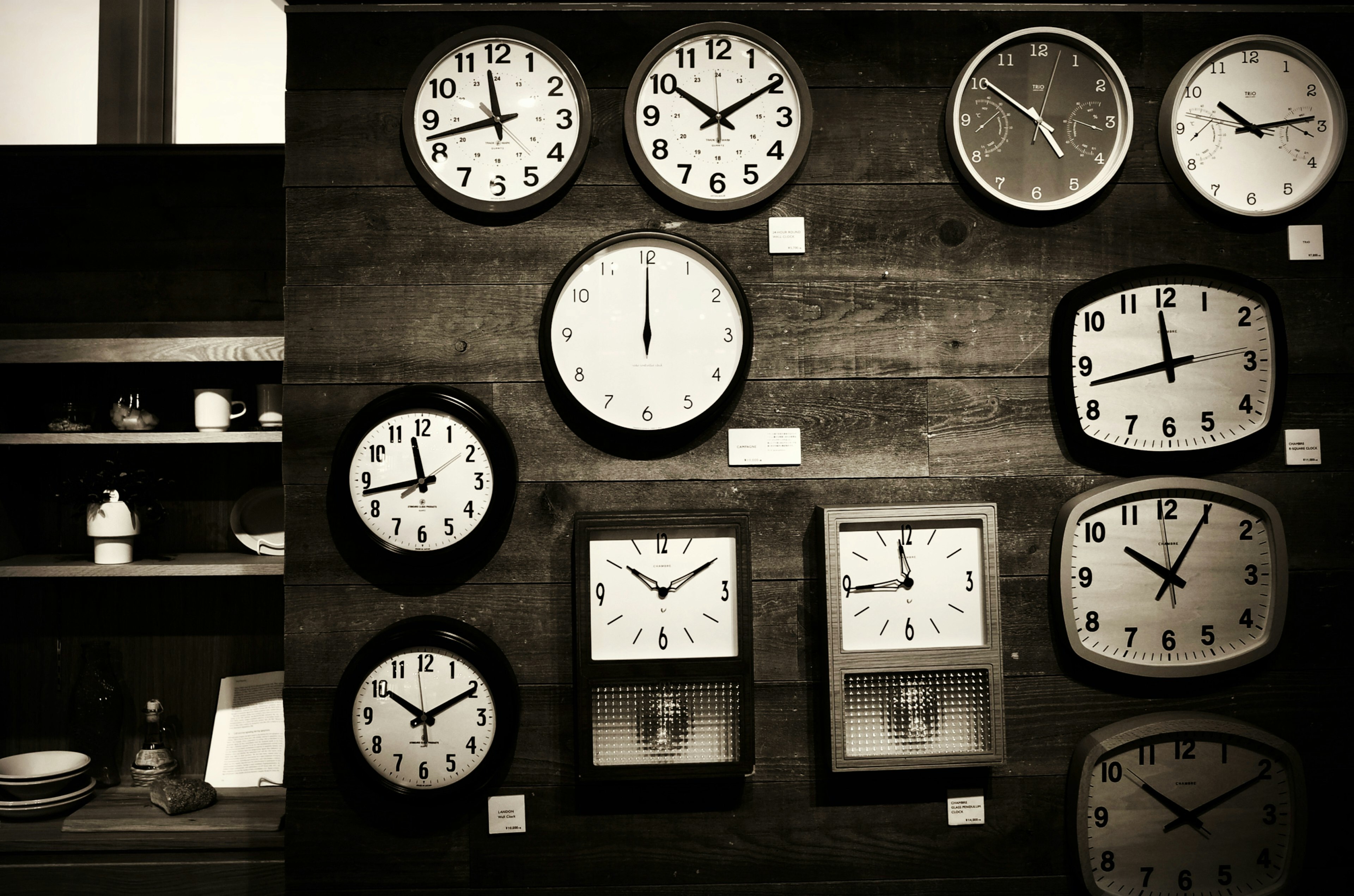 A variety of clocks displayed on a wooden wall showcasing different designs