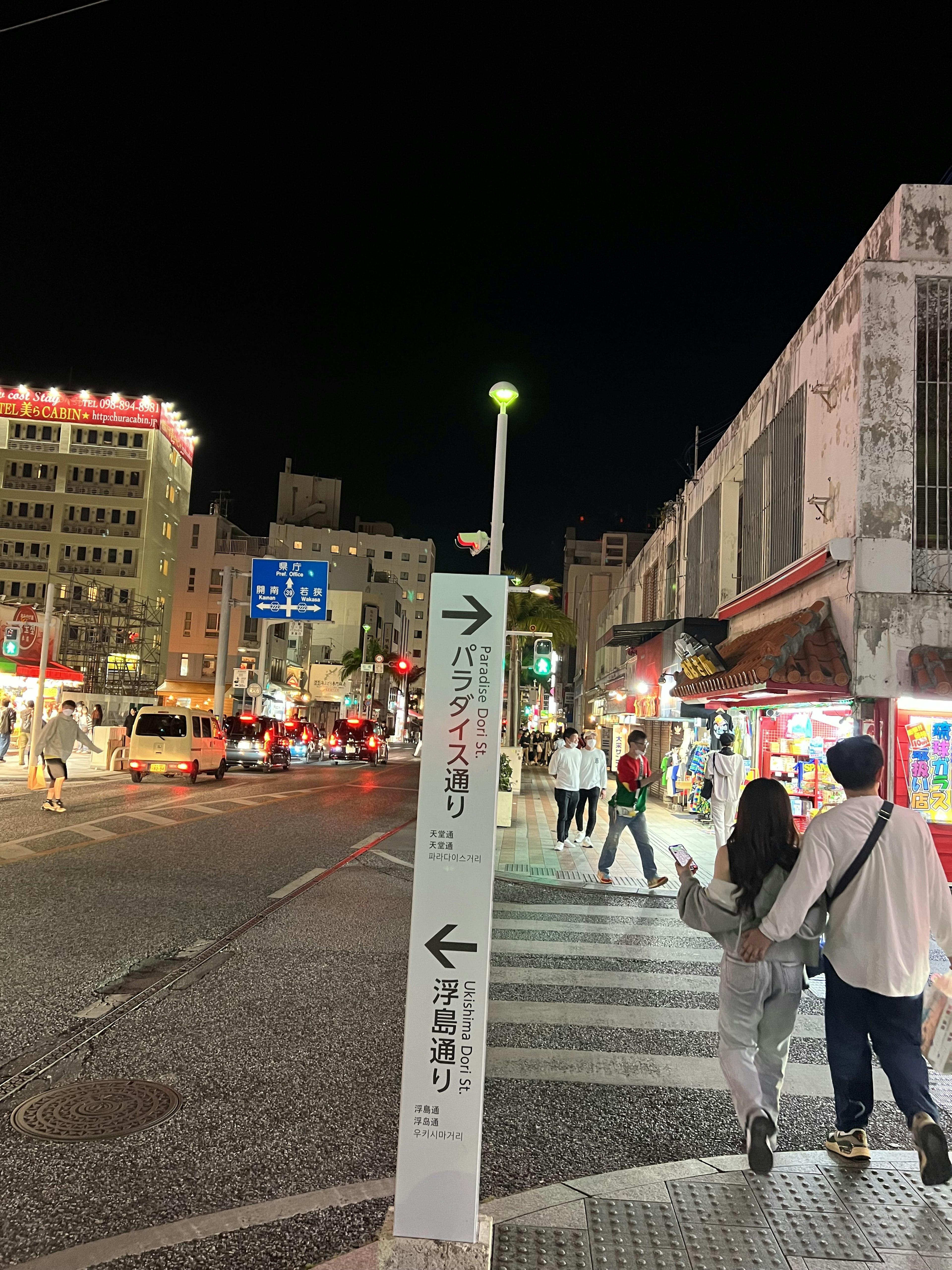 Pareja caminando de noche con señal de tráfico en un entorno urbano