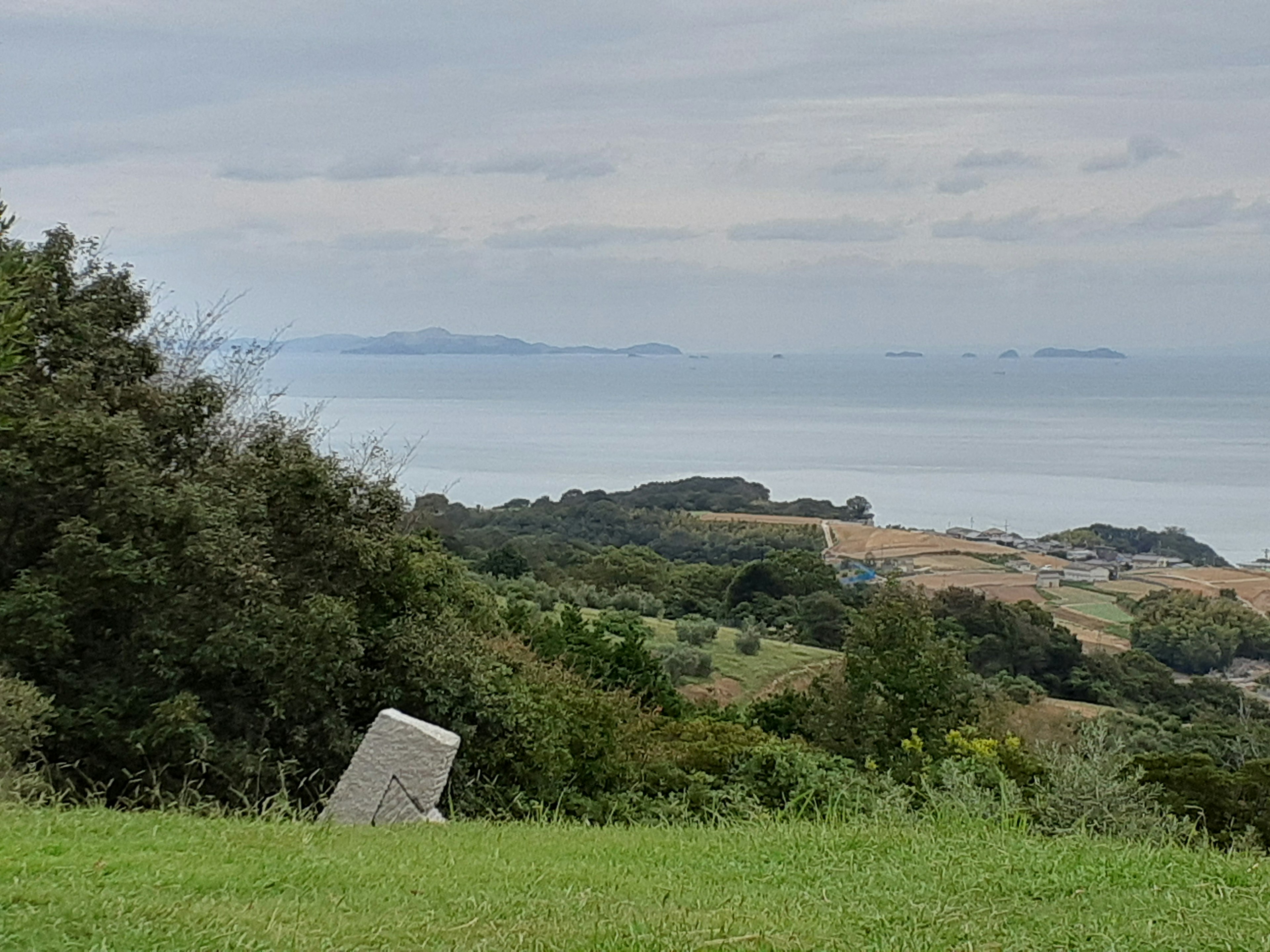 Oggetto di pietra in un paesaggio verde con vista sul mare