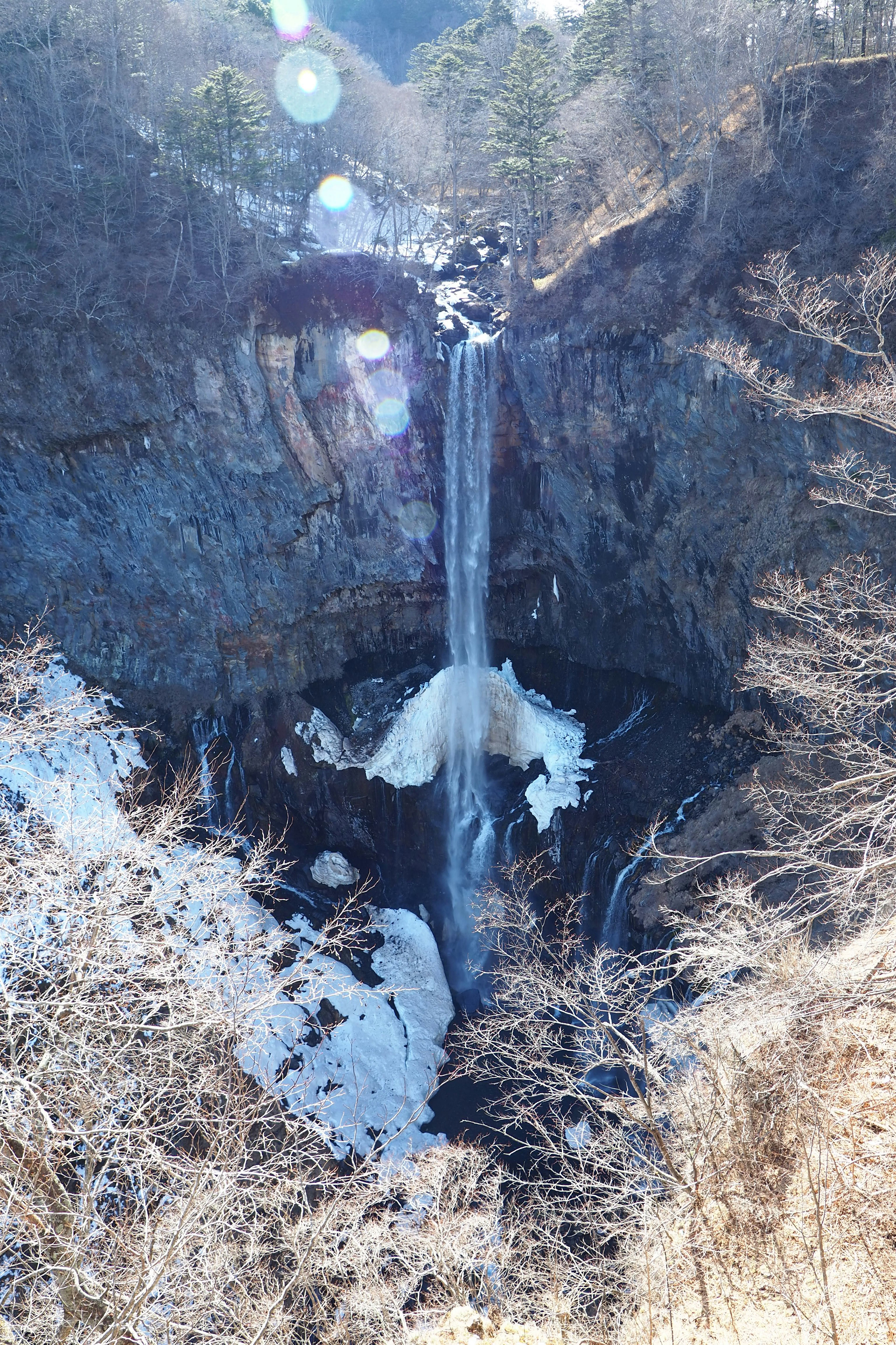 Frozen waterfall surrounded by snow-covered mountains