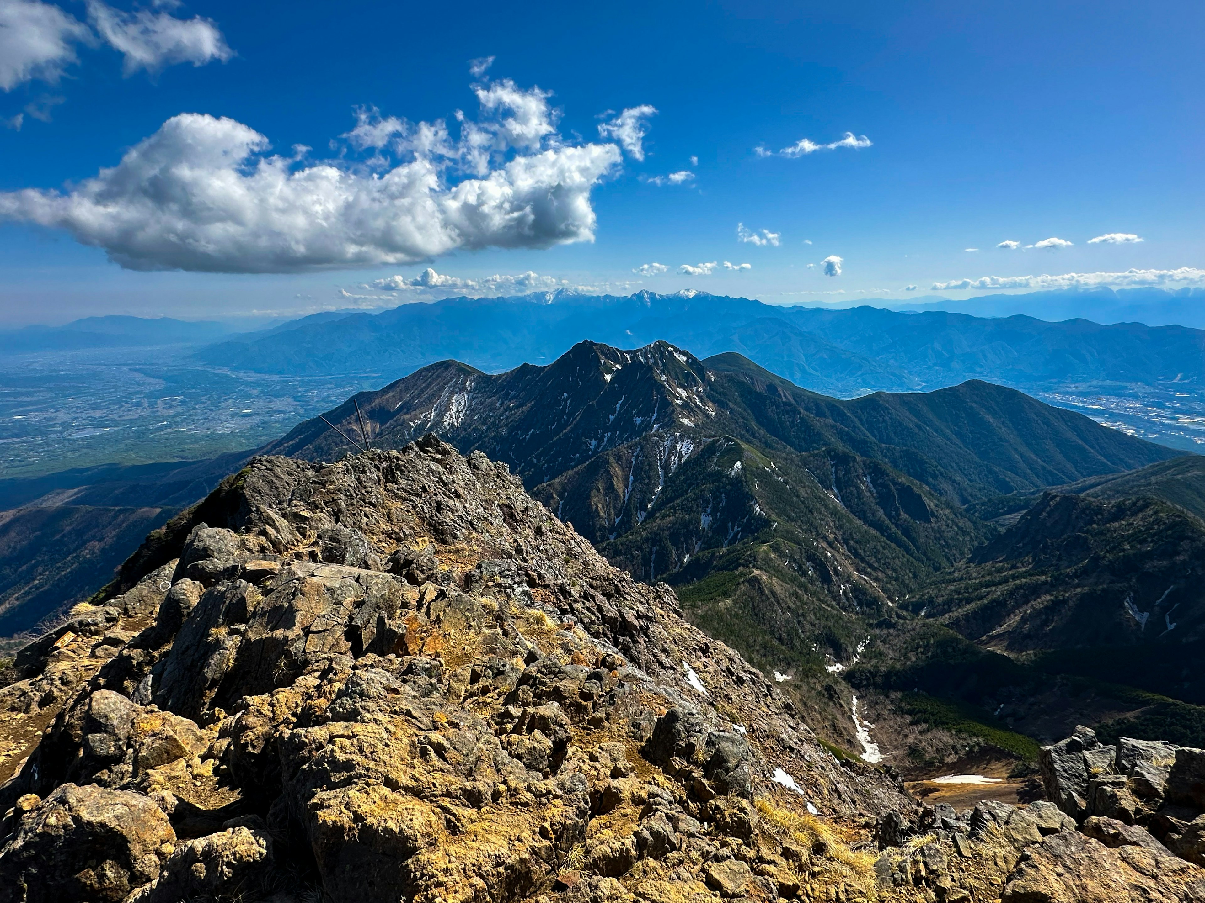 Vista dalla cima della montagna che mostra cielo blu e nuvole montagne lontane superficie rocciosa