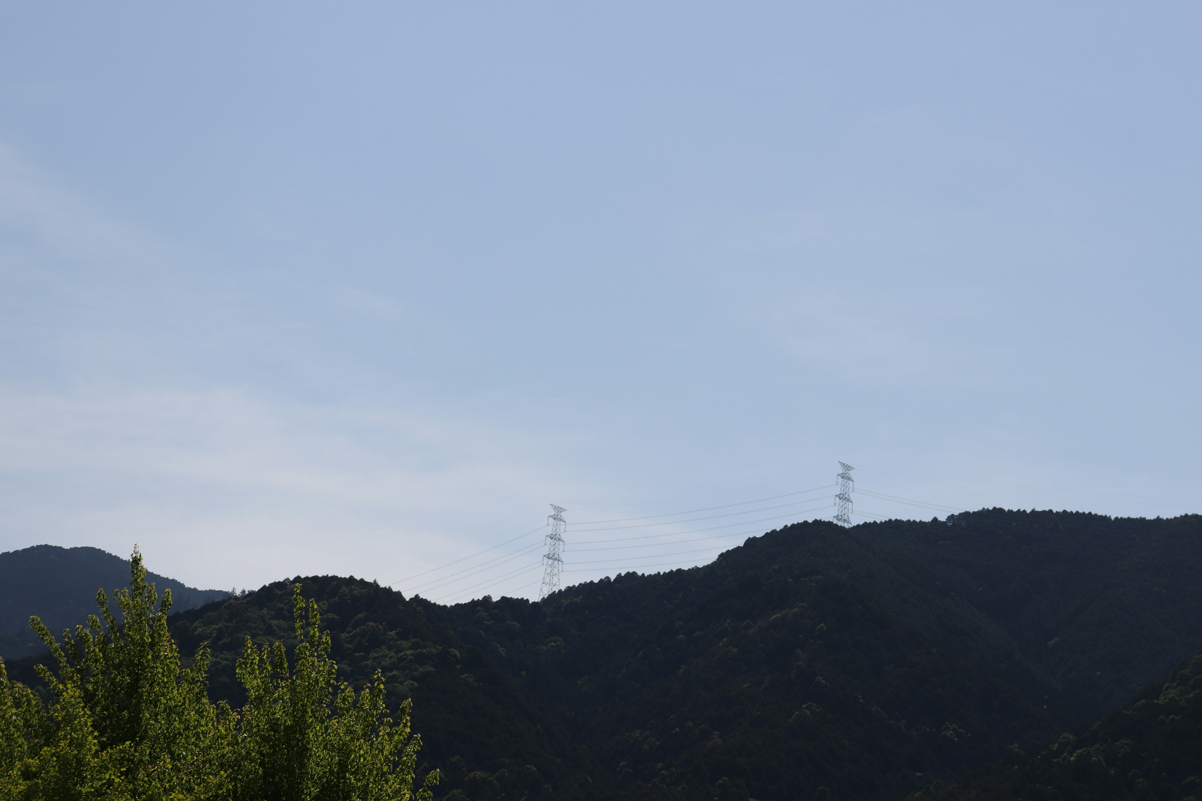 Landschaft mit blauem Himmel und Bergsilhouetten mit Funkmasten