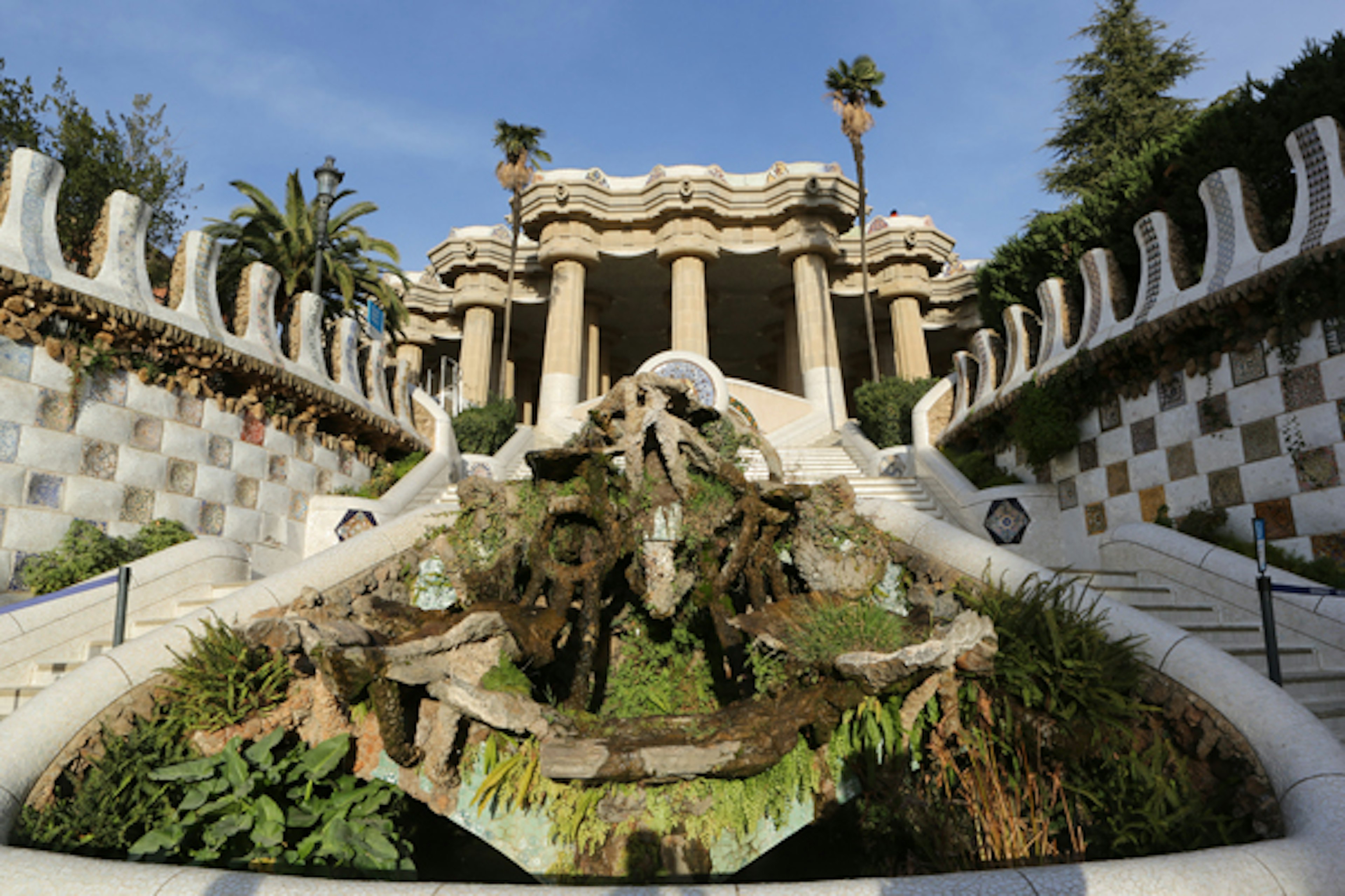 Beautiful facade of Park Güell with fountain and surrounding greenery