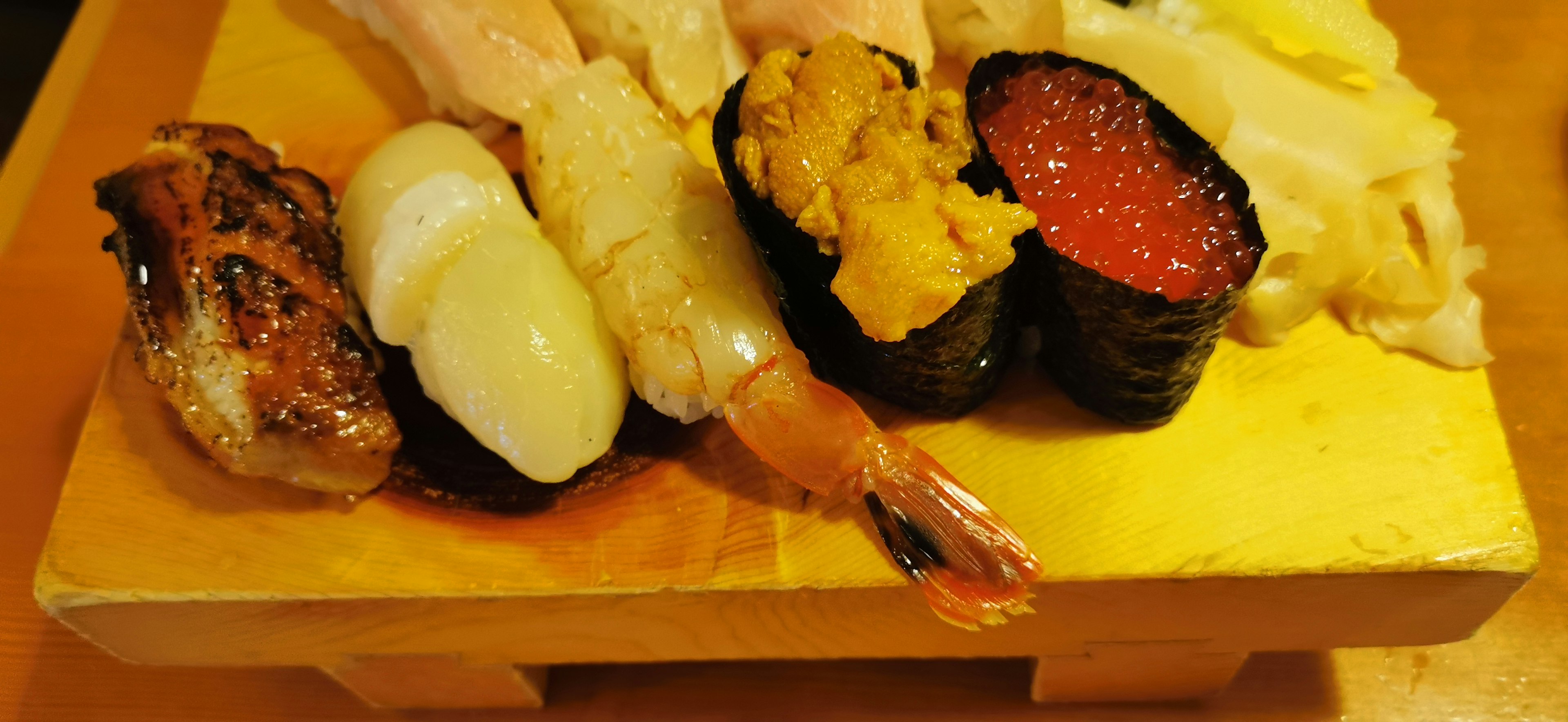 A beautiful sushi platter featuring various types of sushi on a wooden board