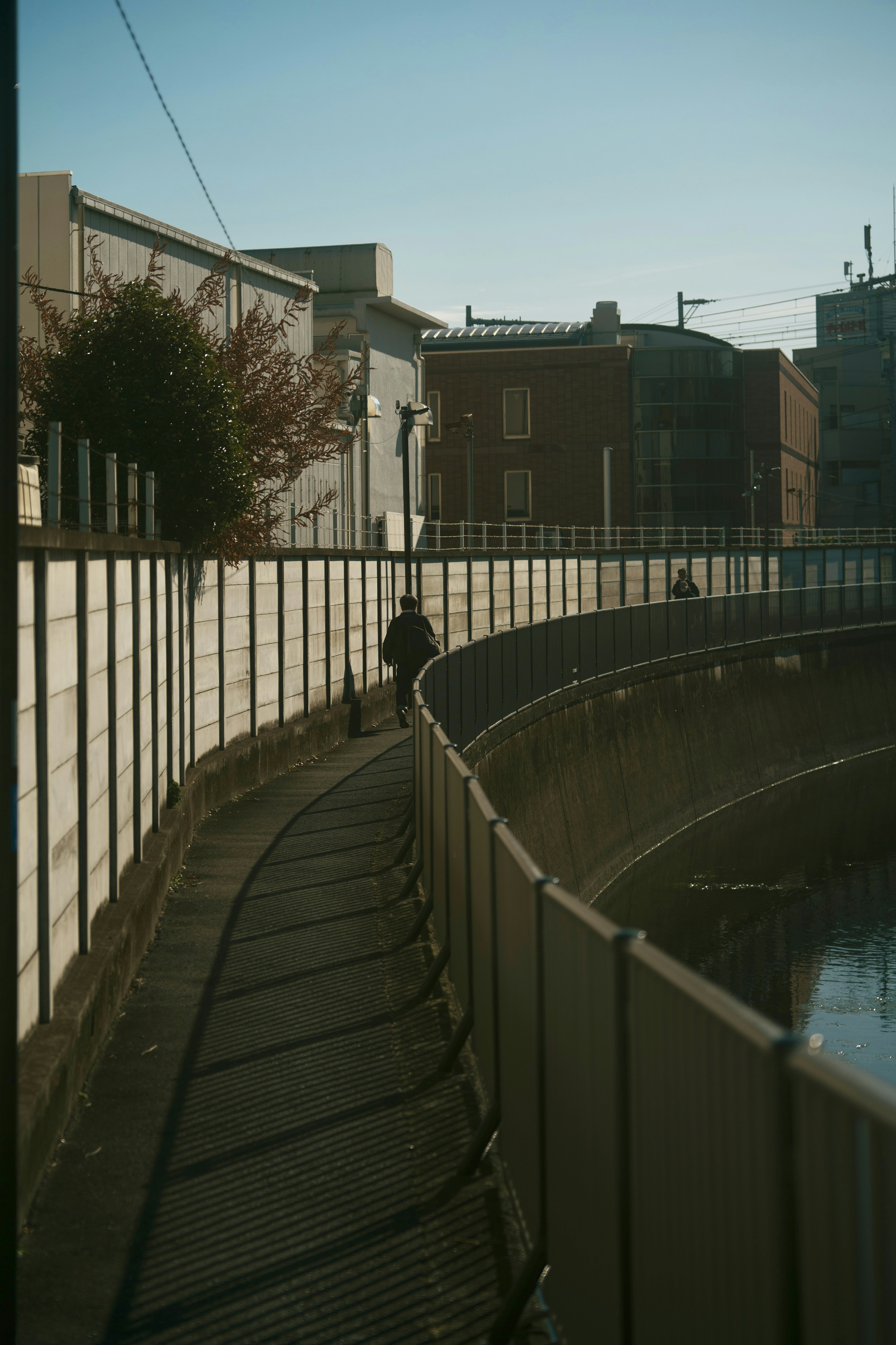 A winding pathway along a river with a person walking