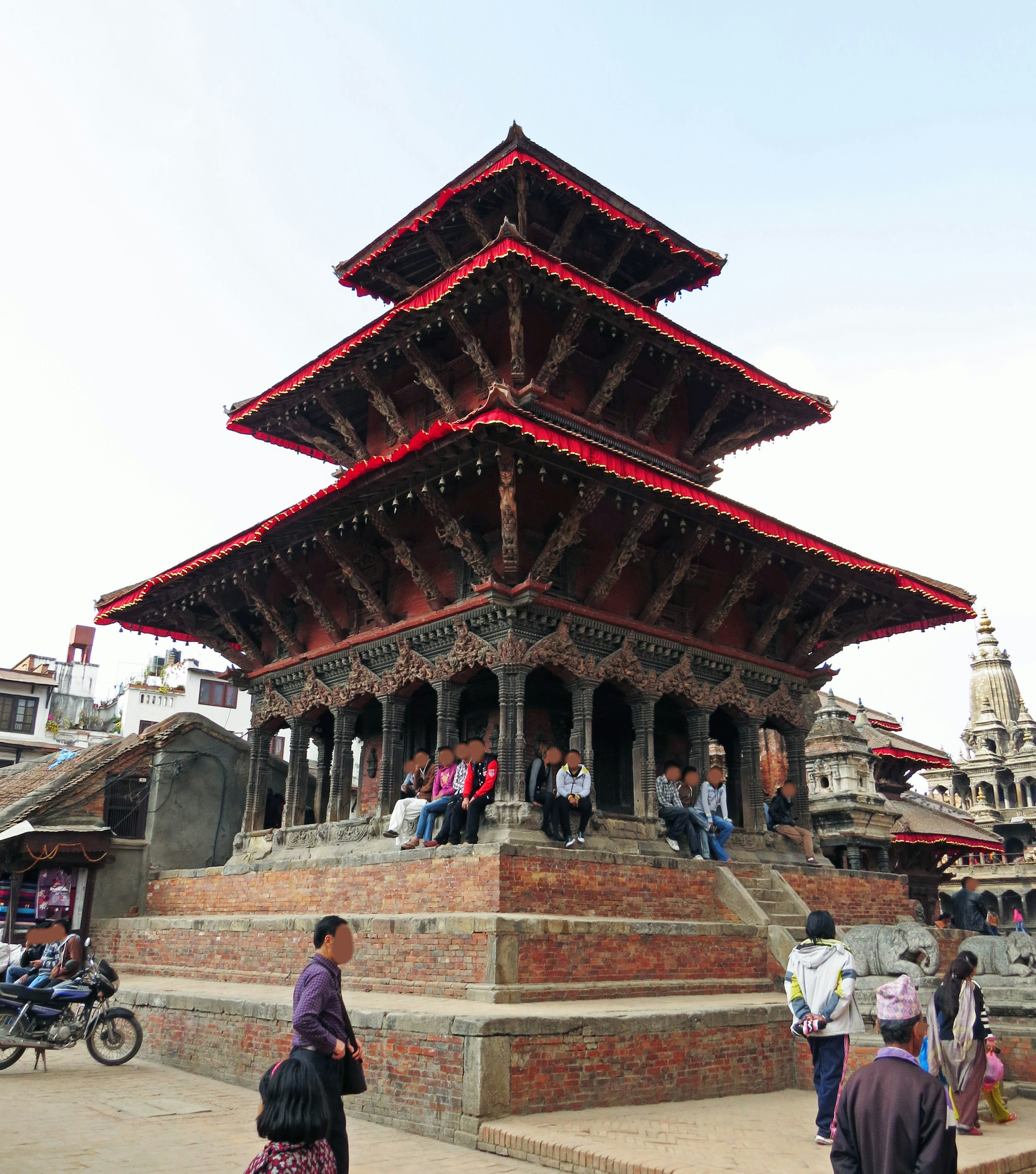 Traditioneller dreistufiger Tempel in Nepal mit roten Dächern und kunstvoll geschnitzten Wänden