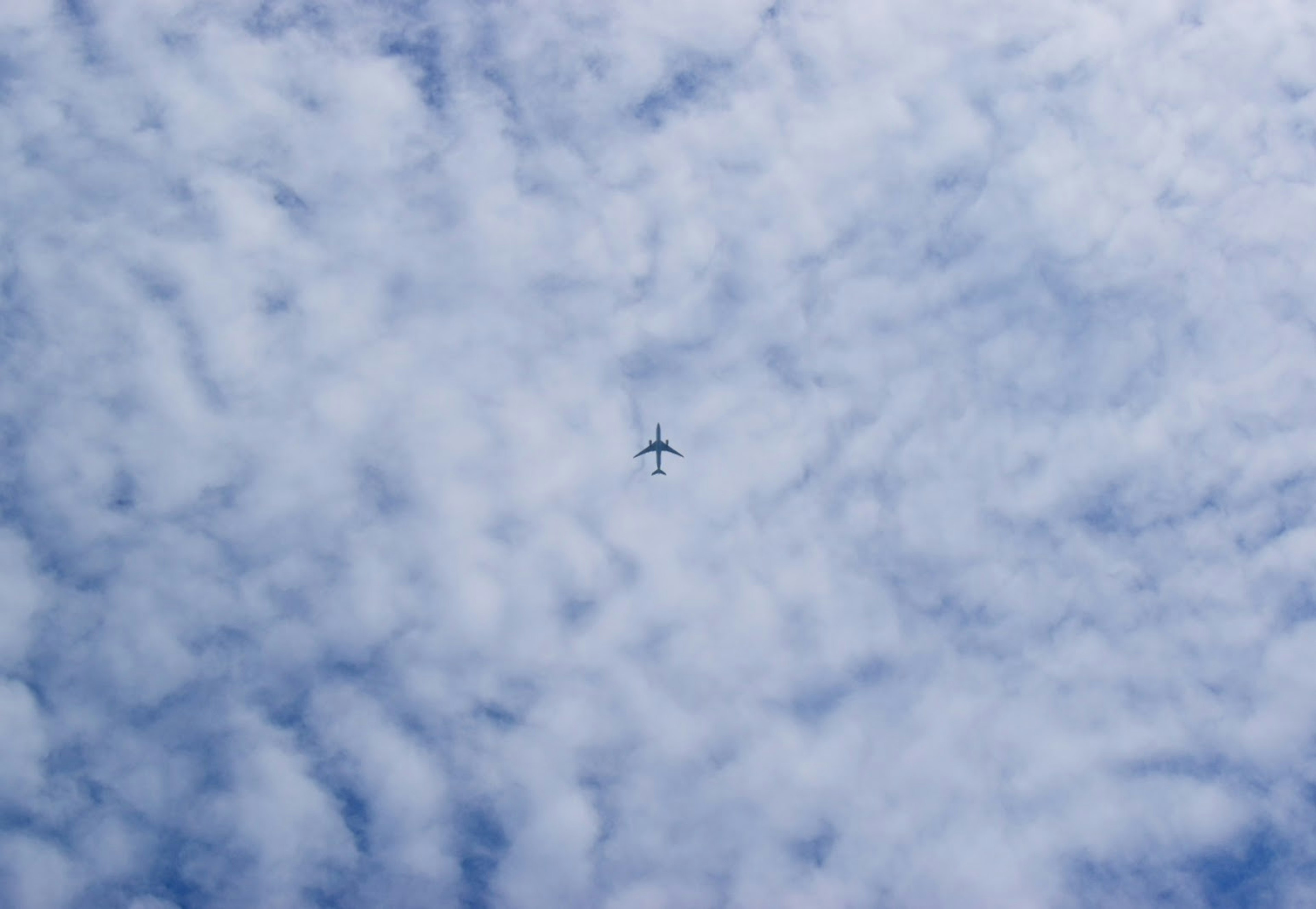 藍天中飛行的飛機和雲彩圖案