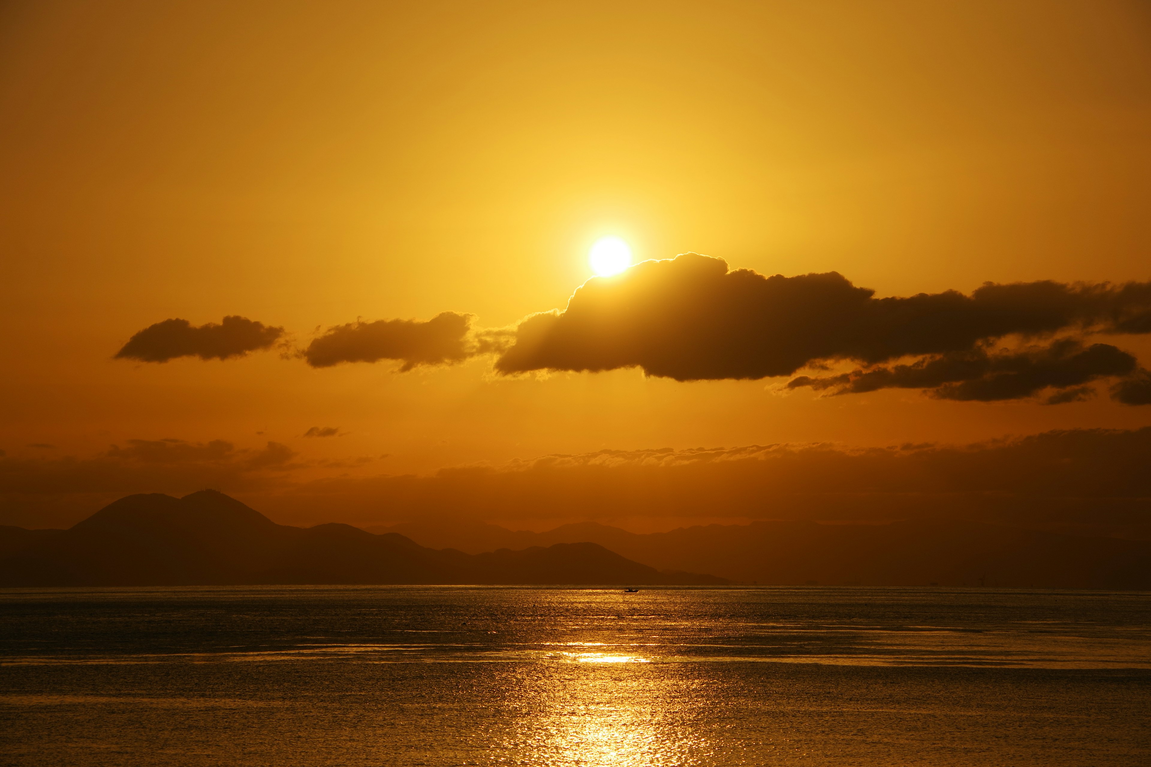 Bellissimo tramonto sull'oceano con il sole che brilla tra le nuvole