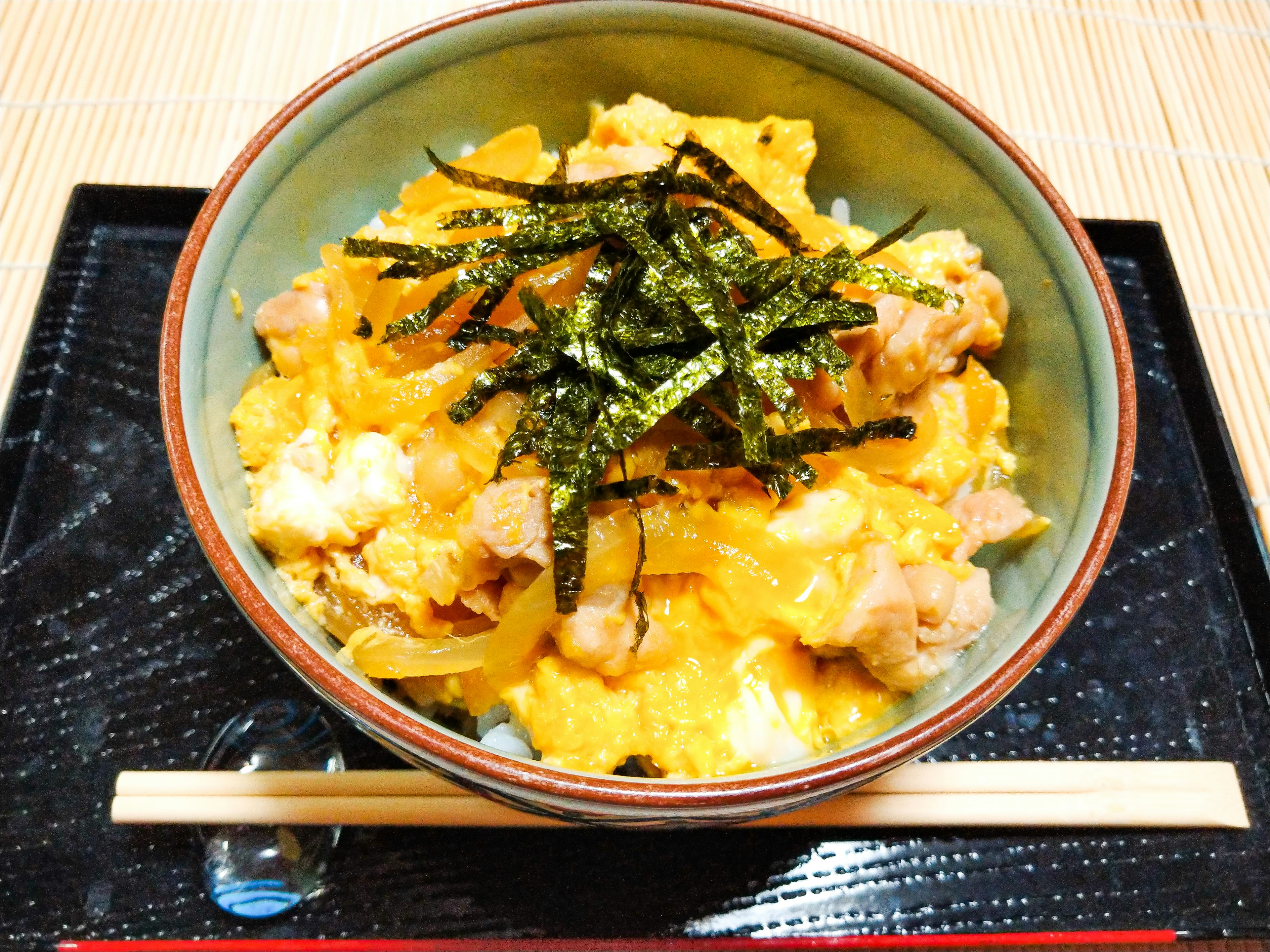 Bowl of oyakodon topped with seaweed