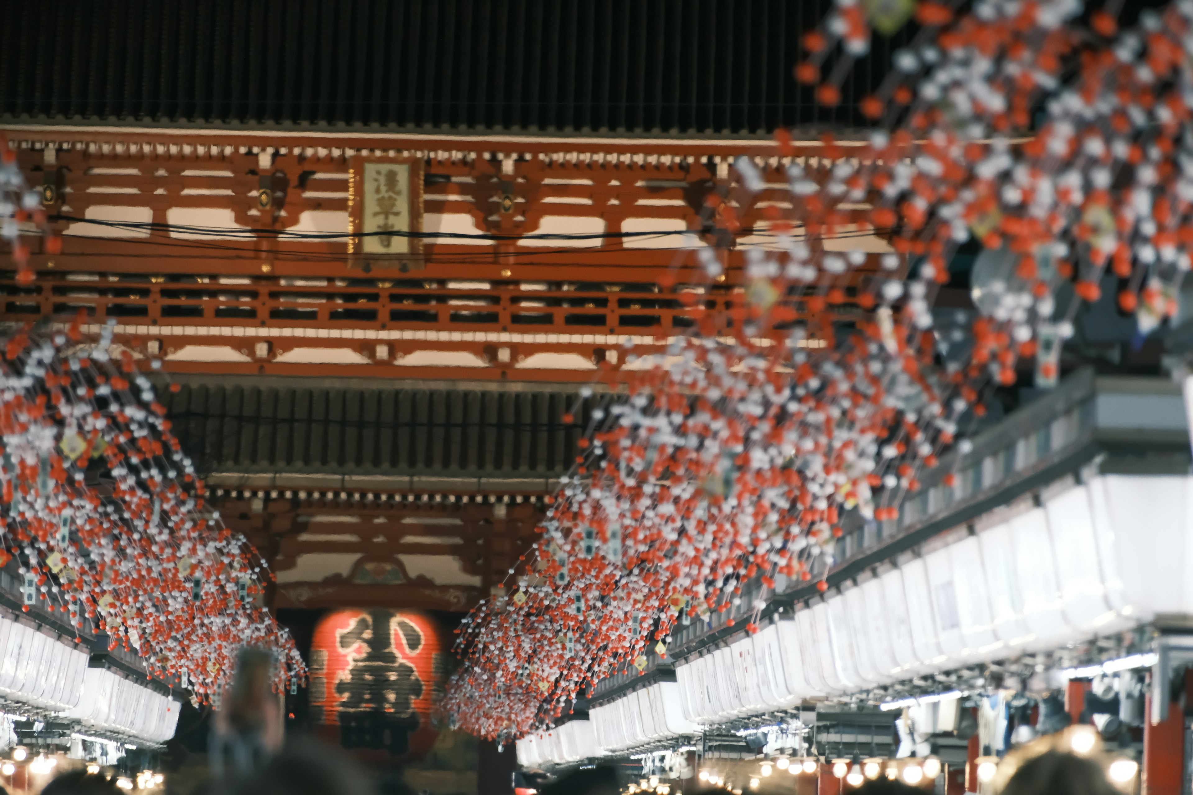 赤と白の提灯が並ぶ賑やかな通りの風景