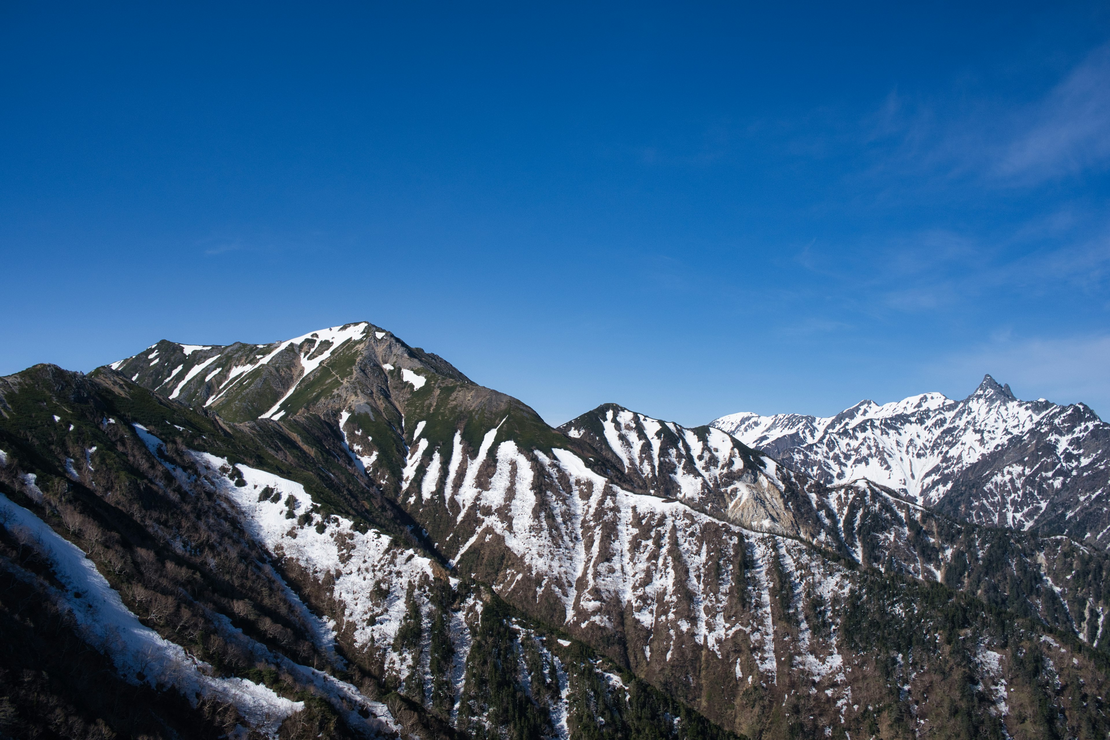 Snow-covered mountains under a clear blue sky