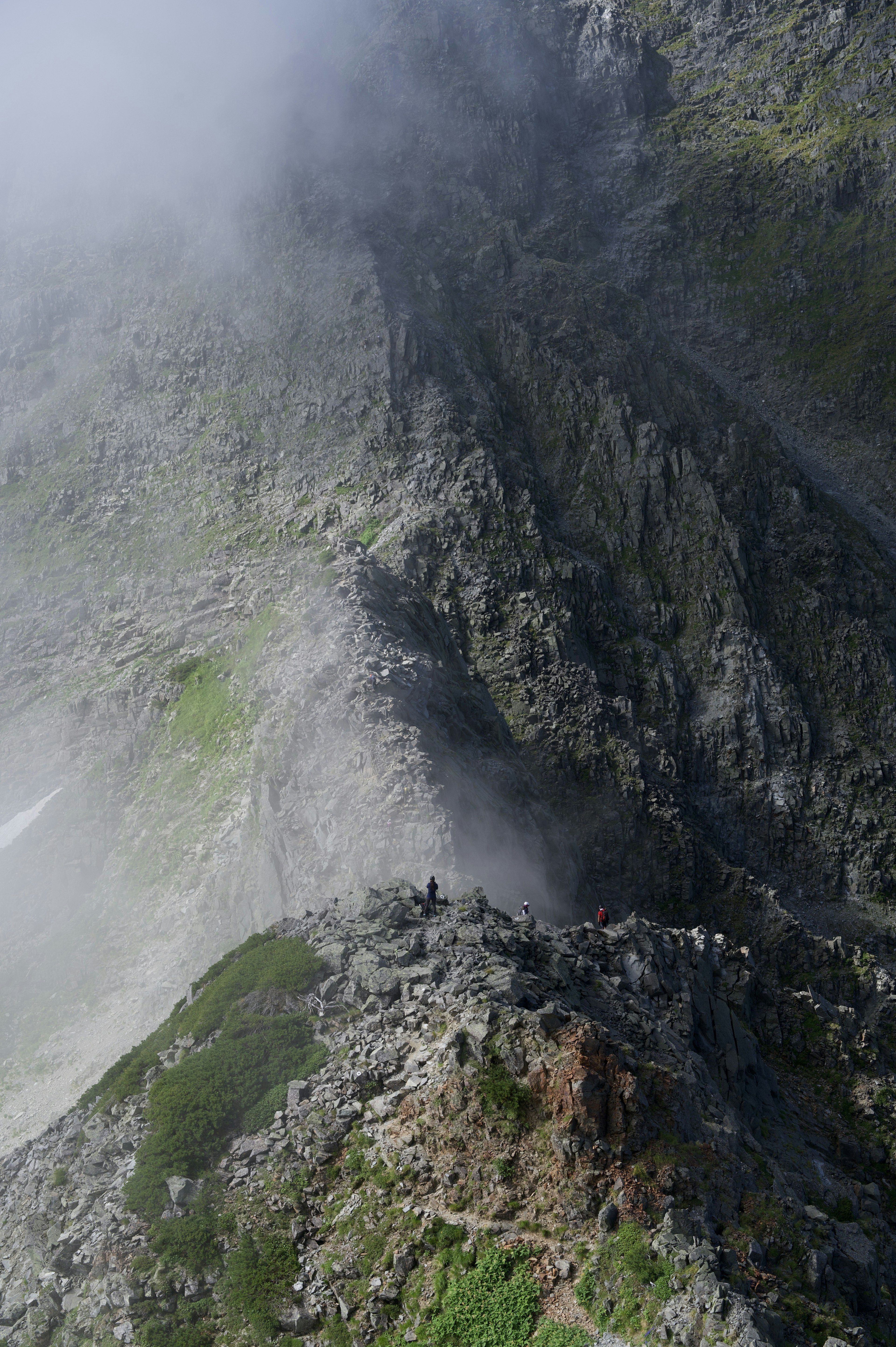 Pendio di montagna avvolto nella nebbia con terreno roccioso