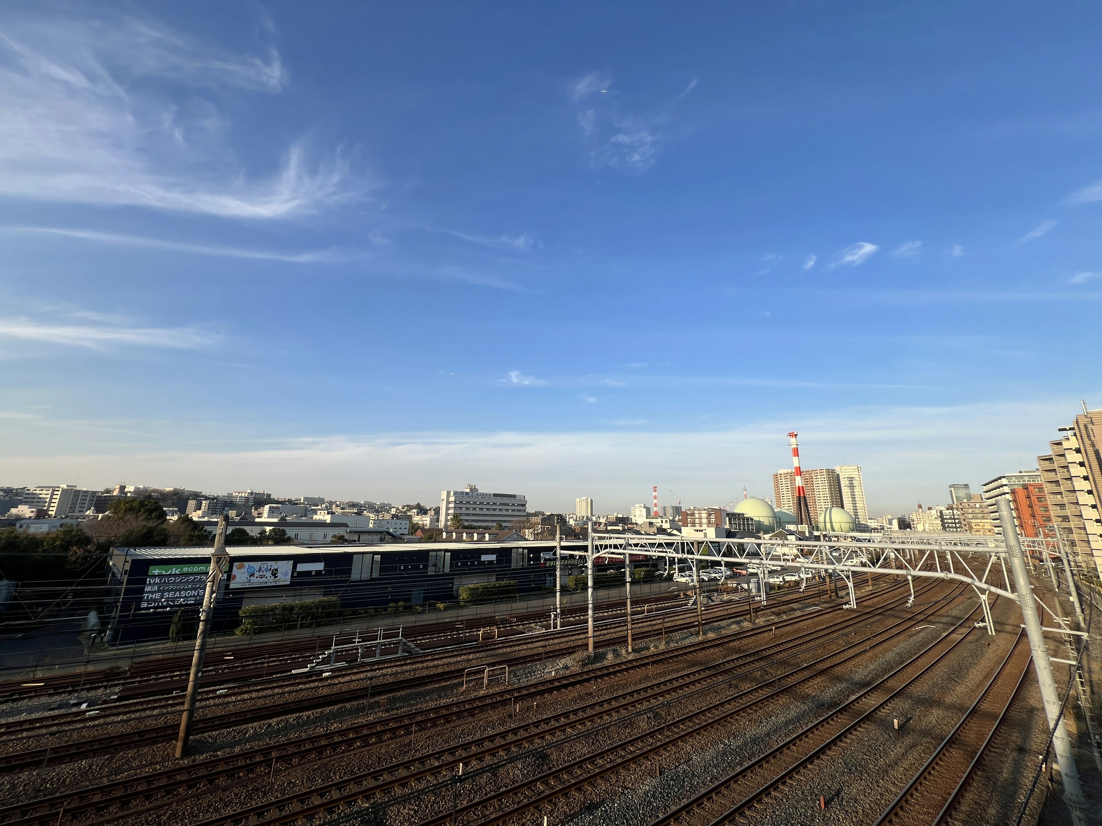 Eisenbahngleise und Stadtlandschaft unter einem klaren blauen Himmel