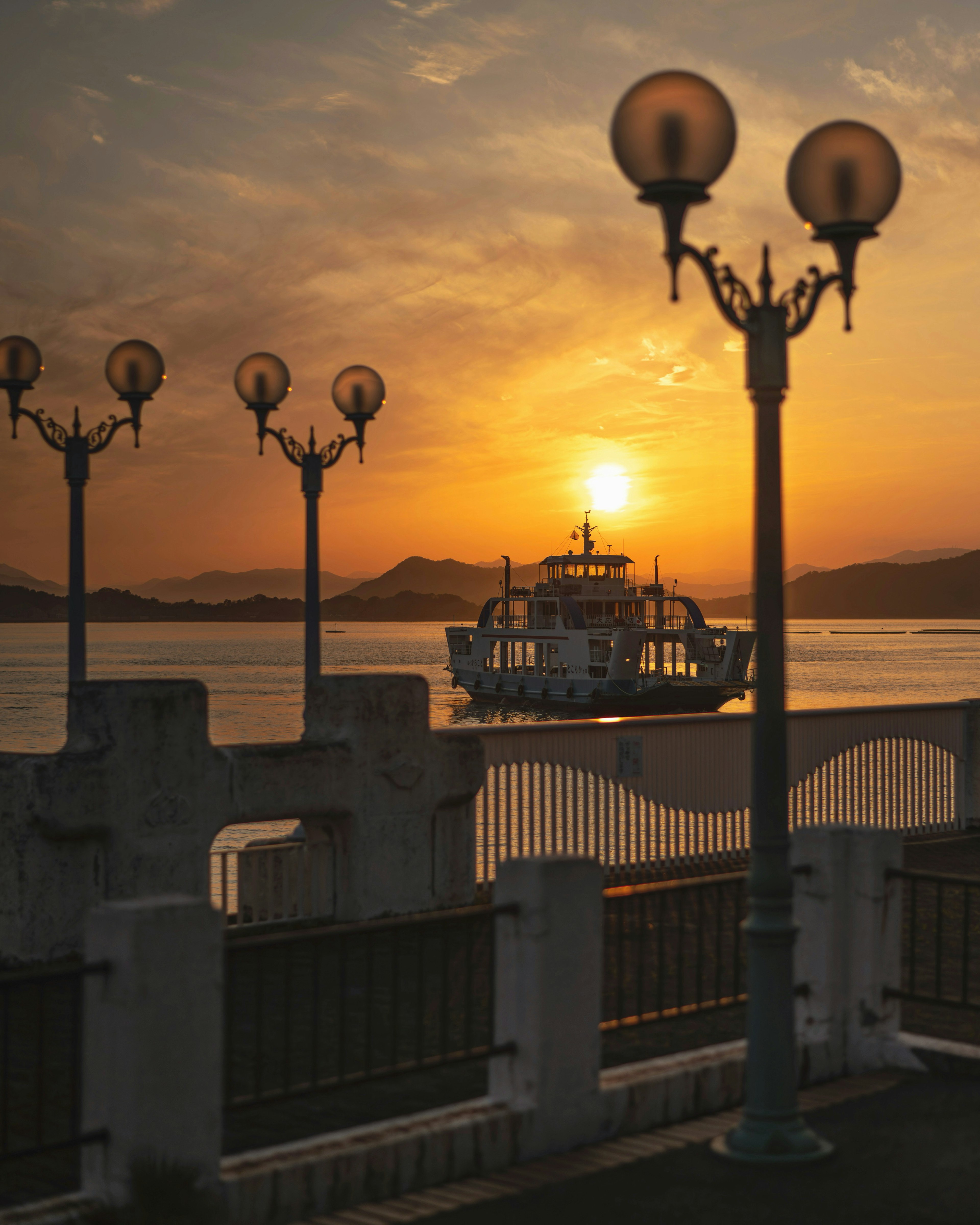 Malersicher Blick auf ein Boot bei Sonnenuntergang mit Straßenlaternen