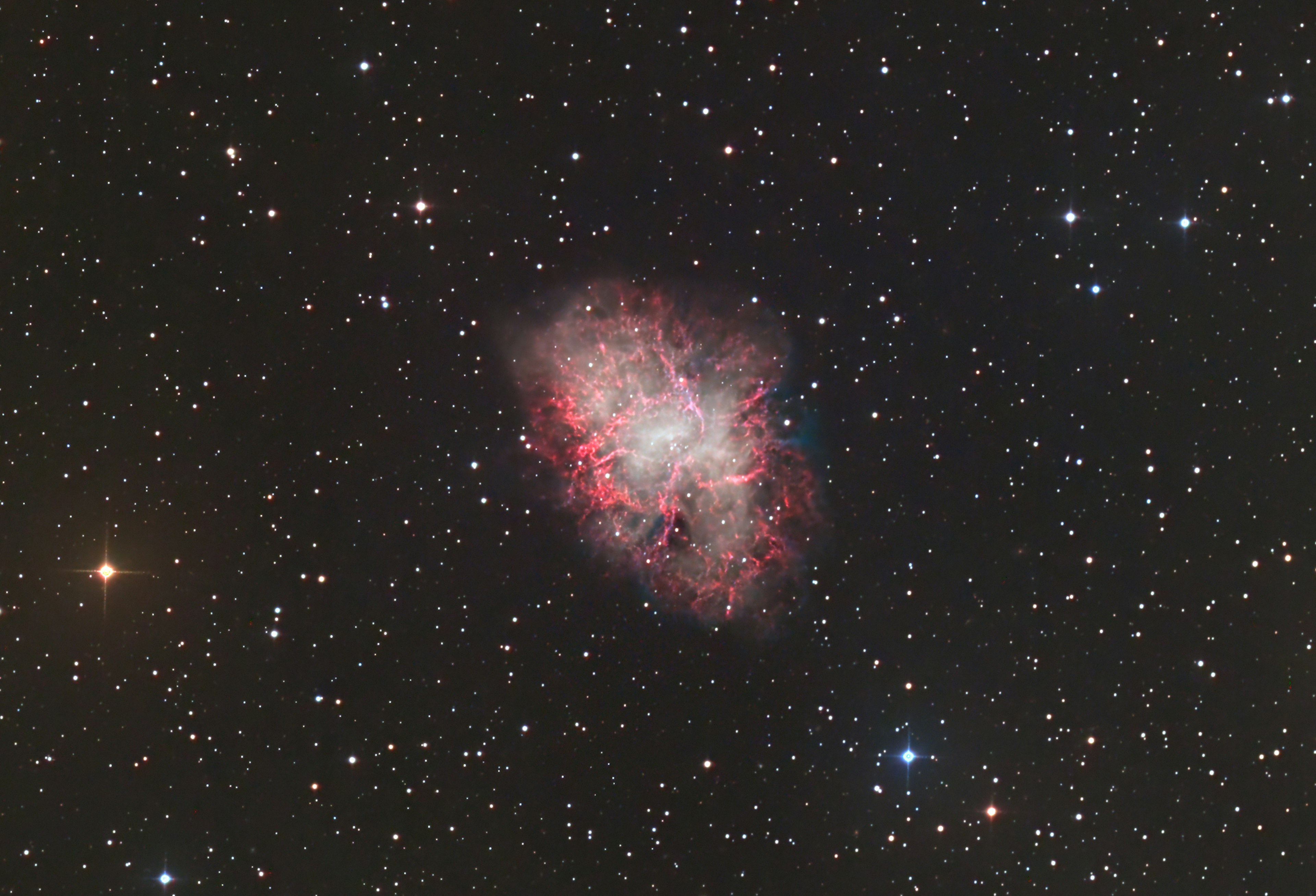 Vivid colors of the Crab Nebula surrounded by sparkling stars in the night sky