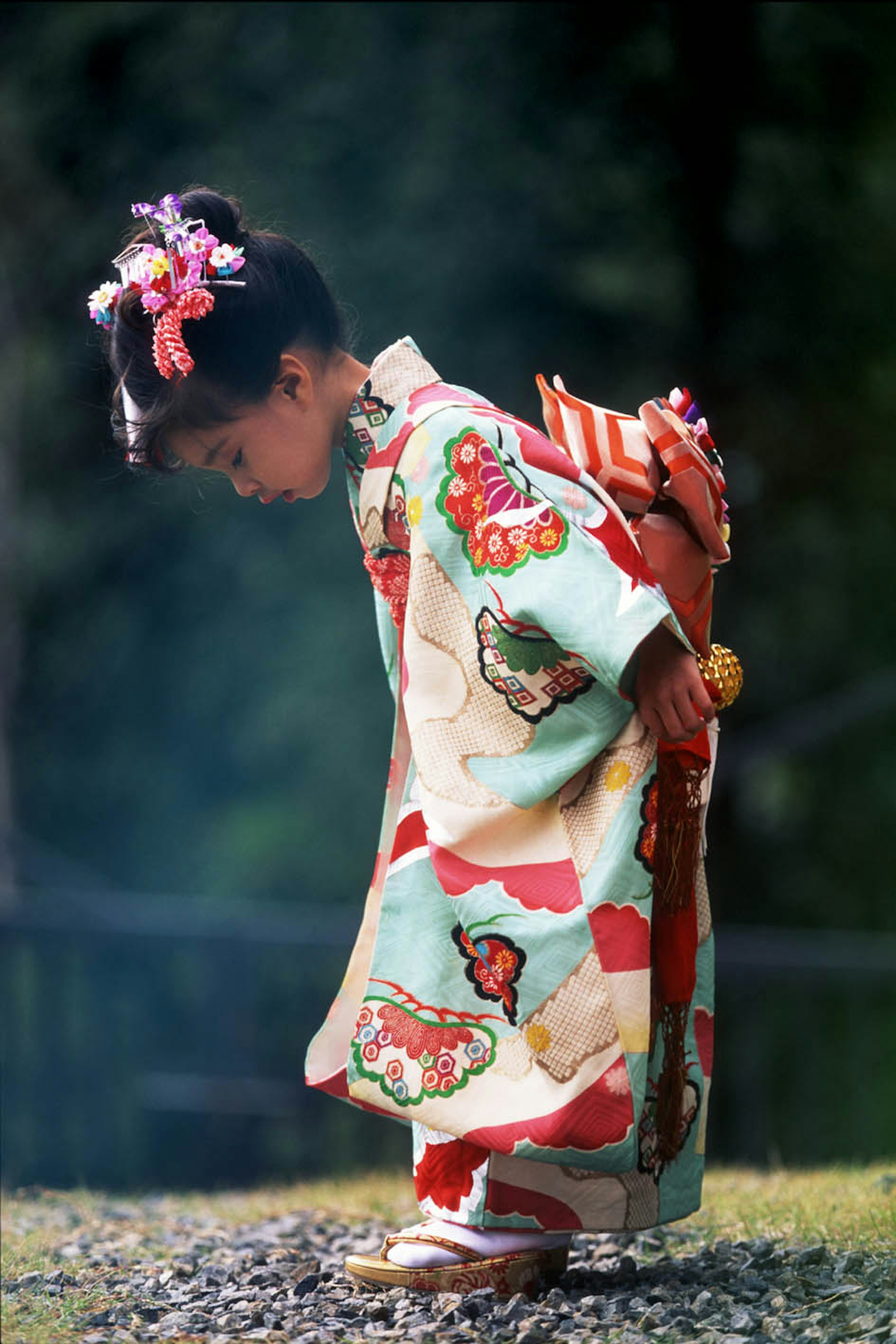 Ein kleines Mädchen im Kimono verbeugt sich anmutig