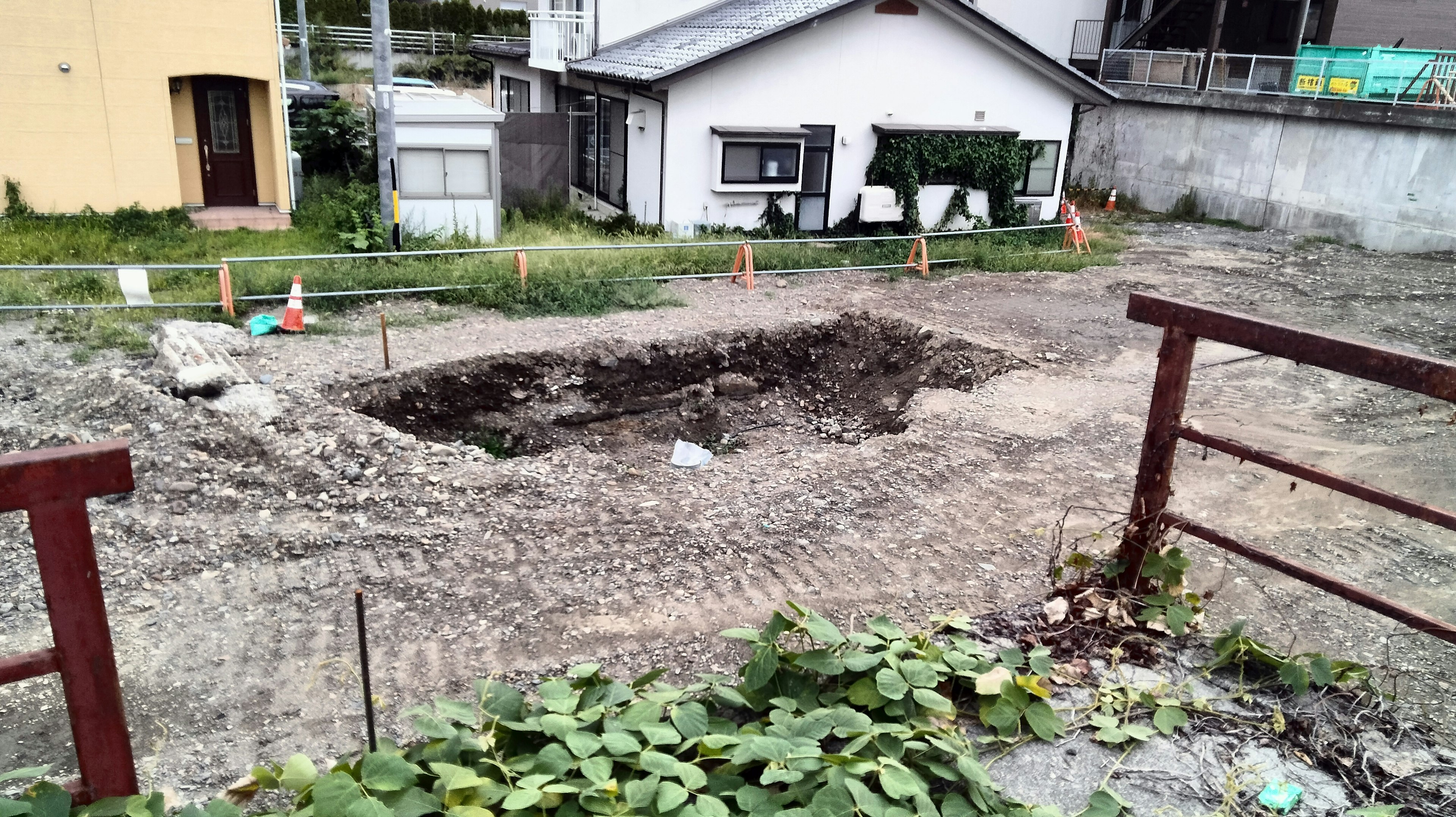 Excavated area with a hole and surrounding buildings