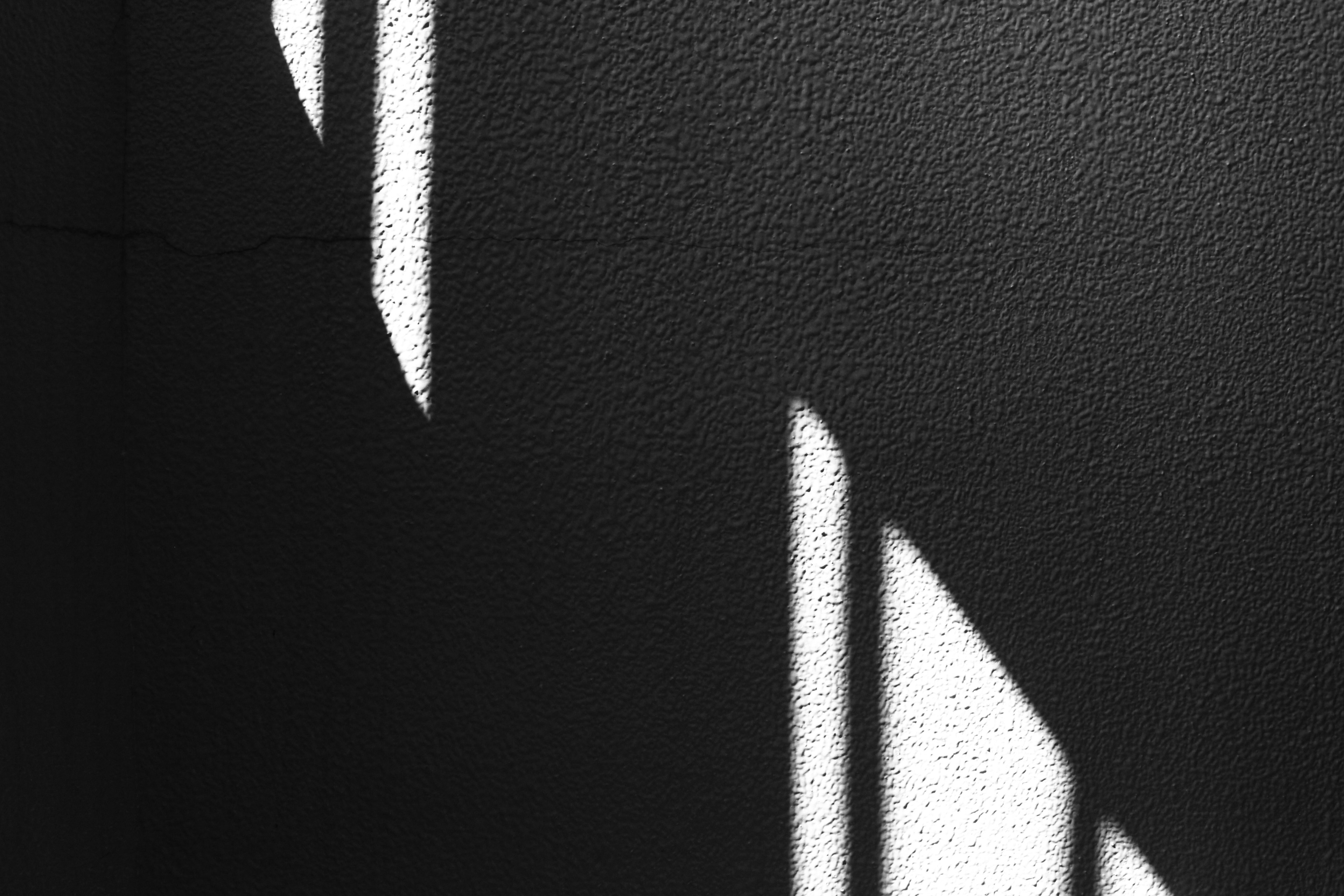 Patrones geométricos de sombras en una pared en blanco y negro