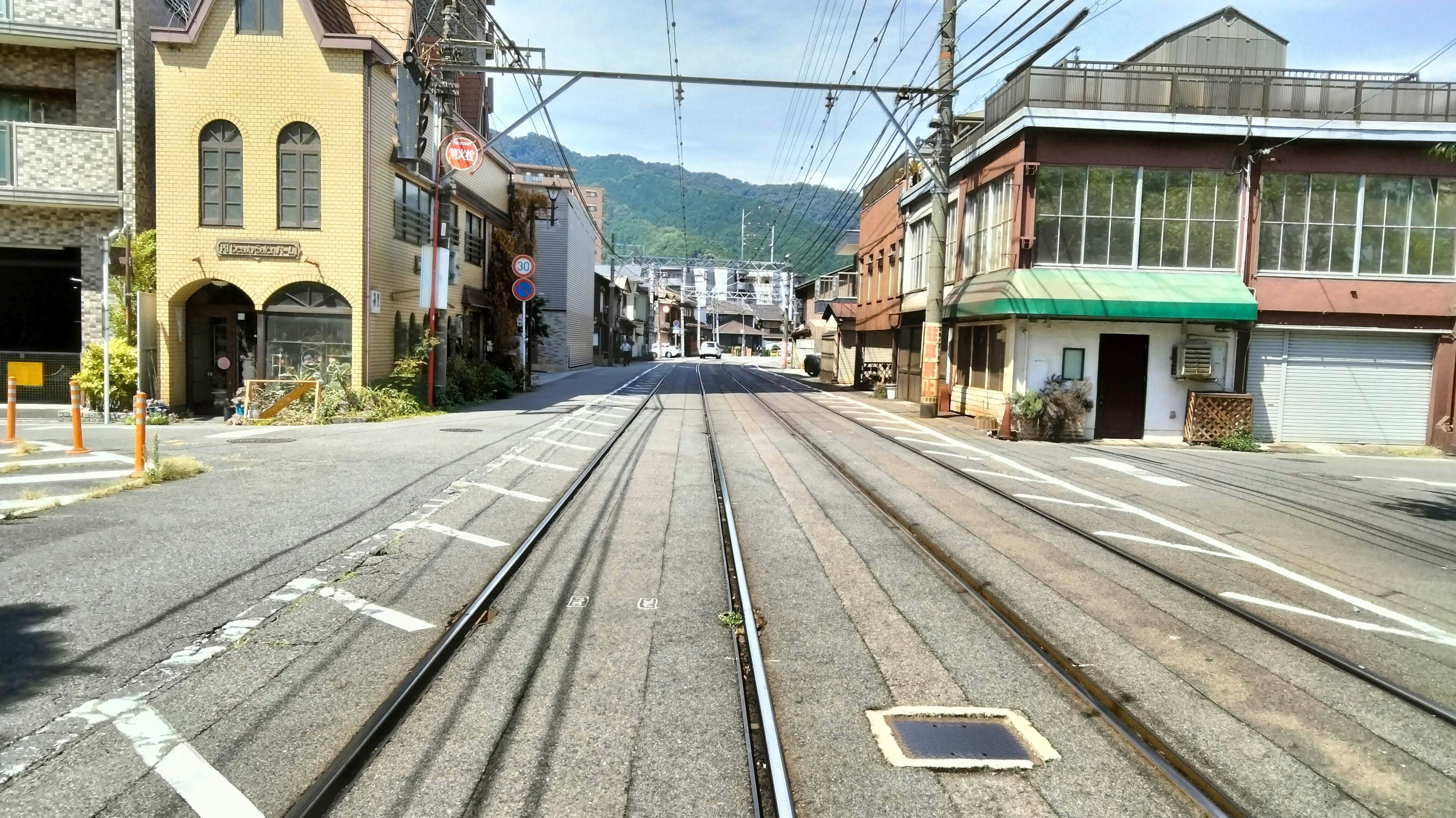 Pemandangan jalan yang tenang dengan rel trem yang bersilangan