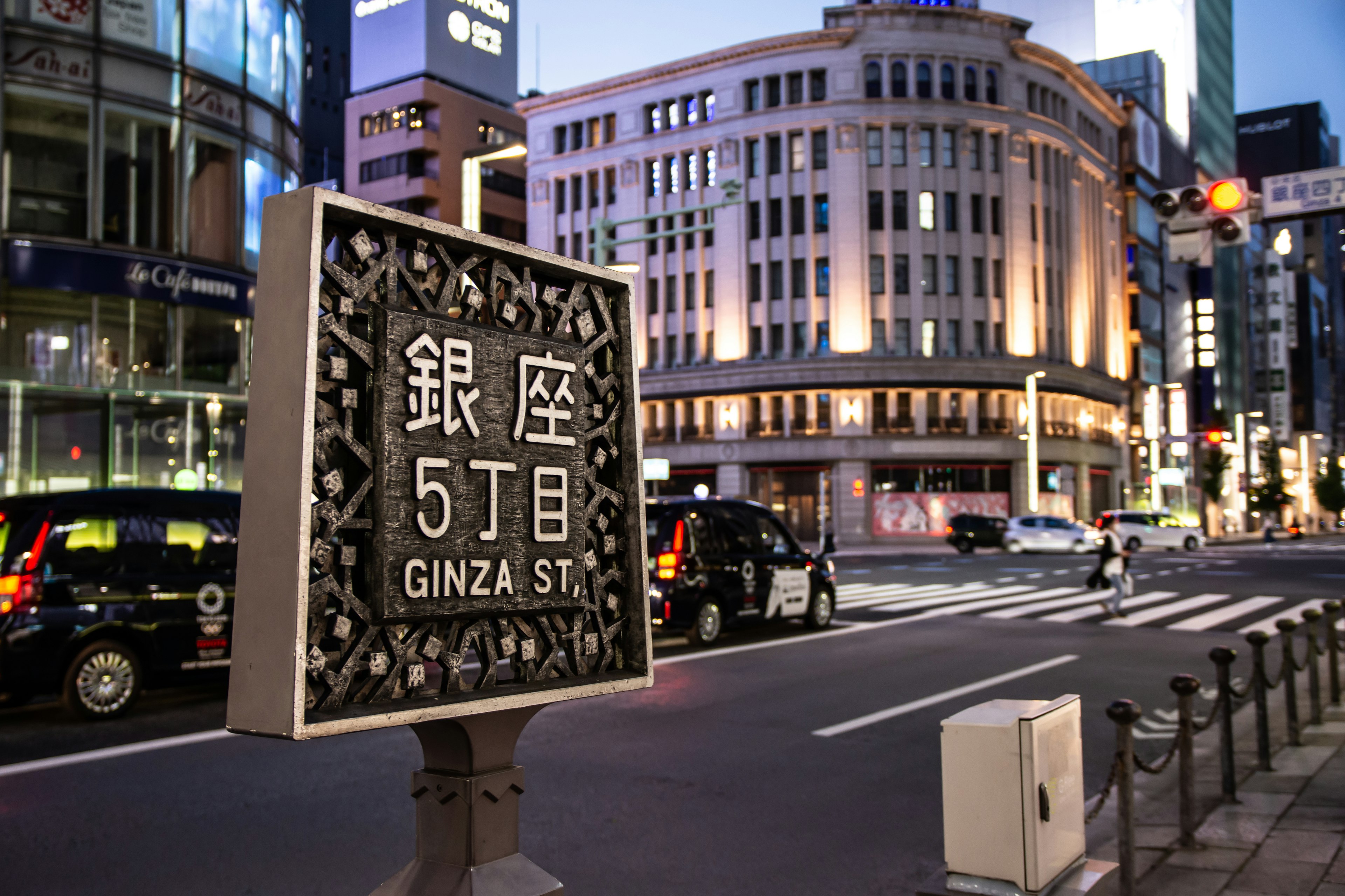 Insegna di Ginza 5 con lo skyline circostante di notte