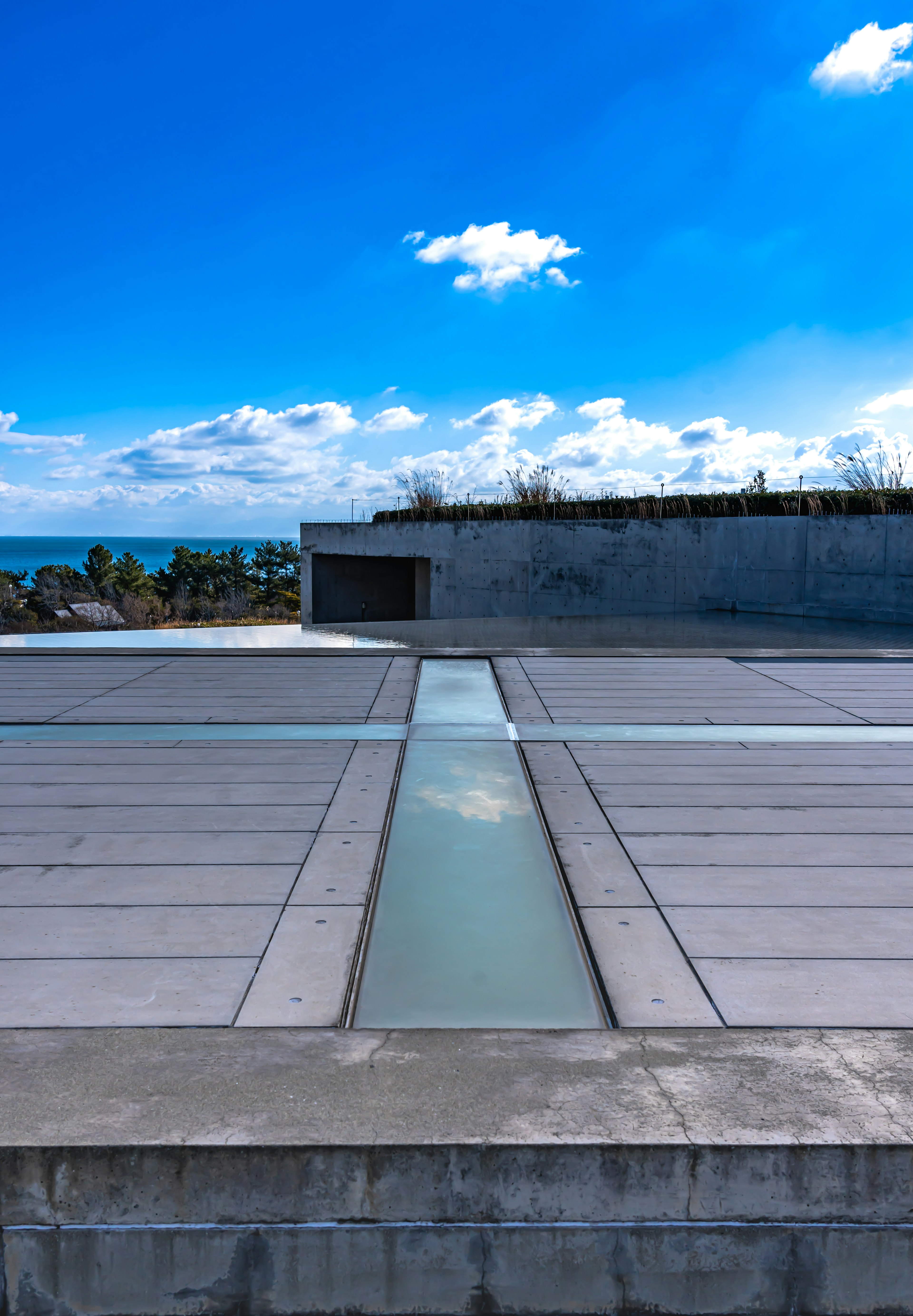 Pemandangan atap dengan langit biru dan awan desain beton dan kaca