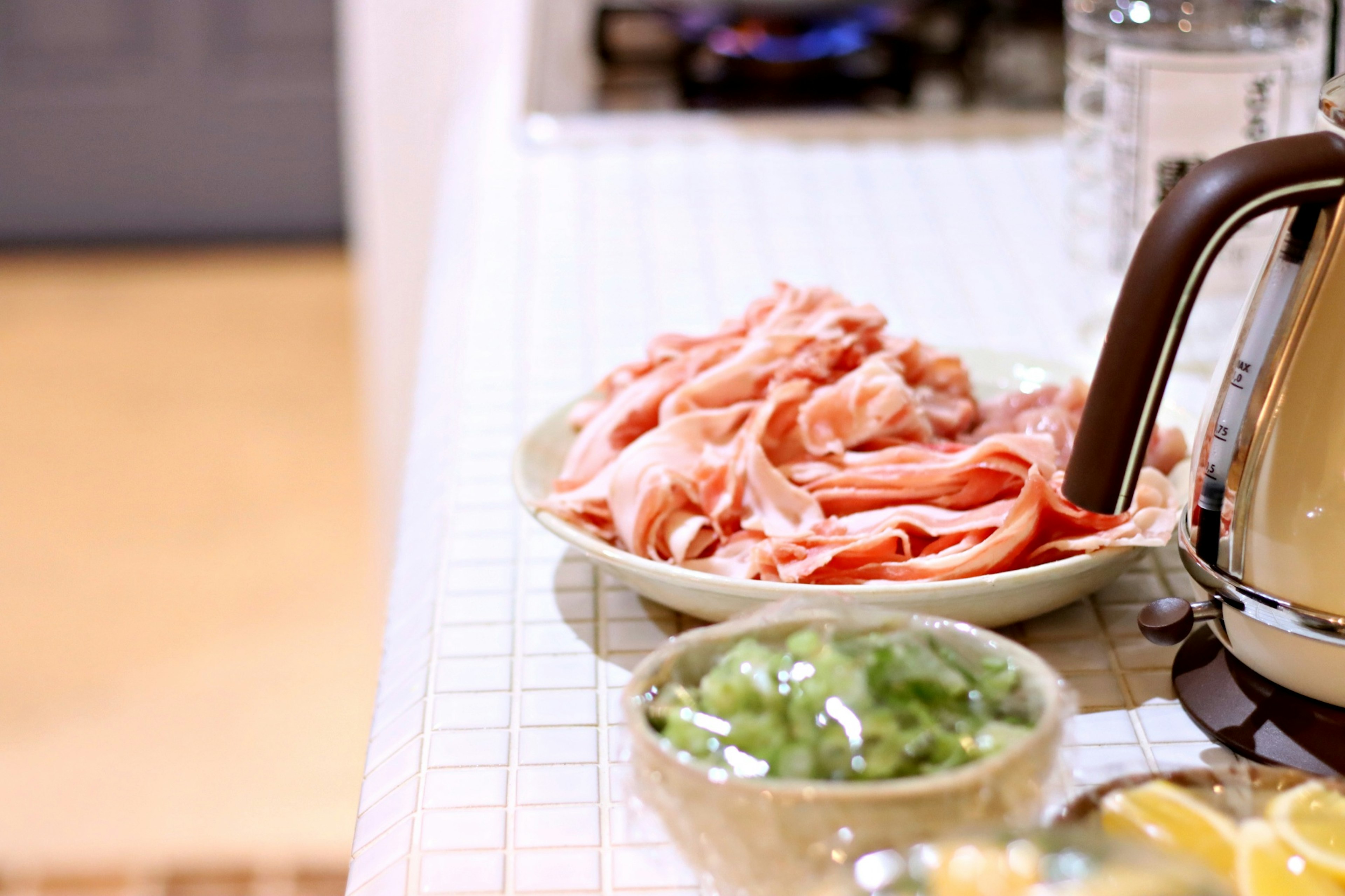 Thinly sliced pork and green vegetables arranged for cooking