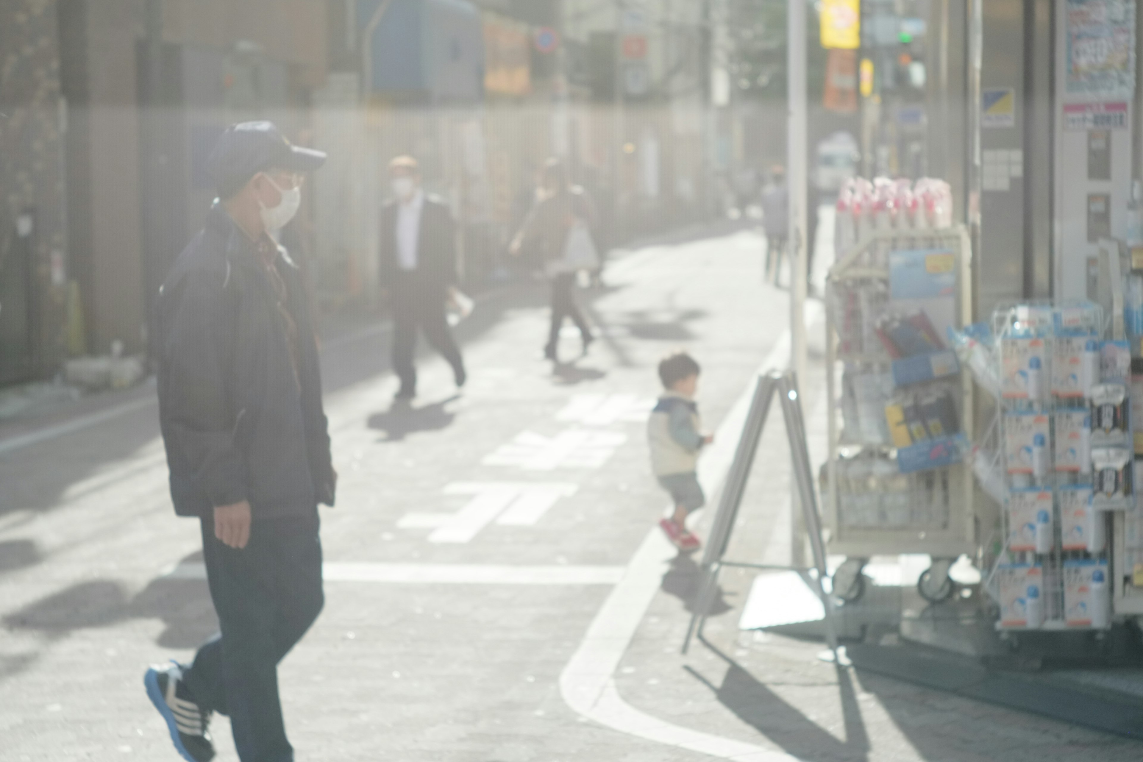 A bustling street scene with pedestrians and a child playing