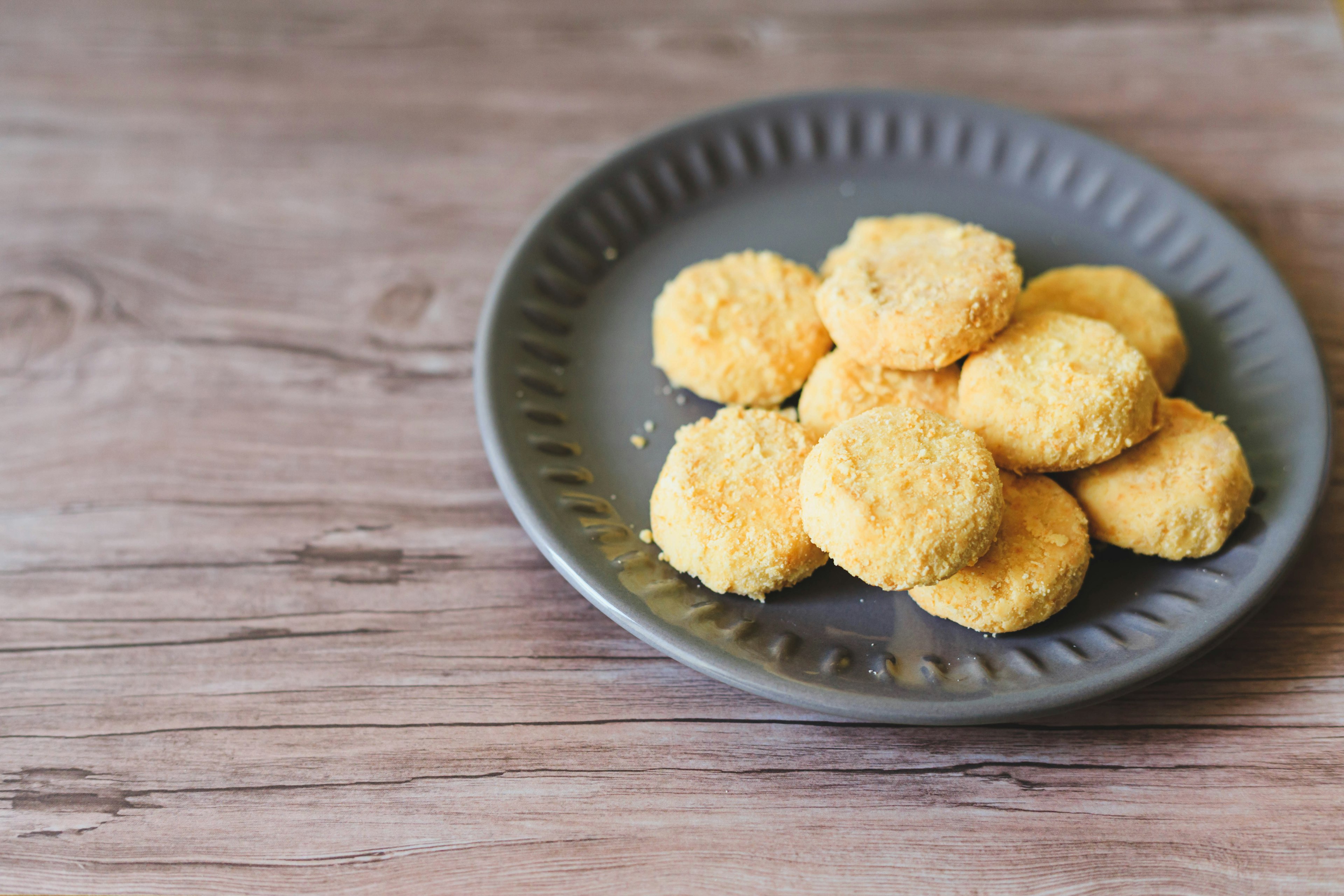 Goldene Nuggets auf einem grauen Teller angeordnet