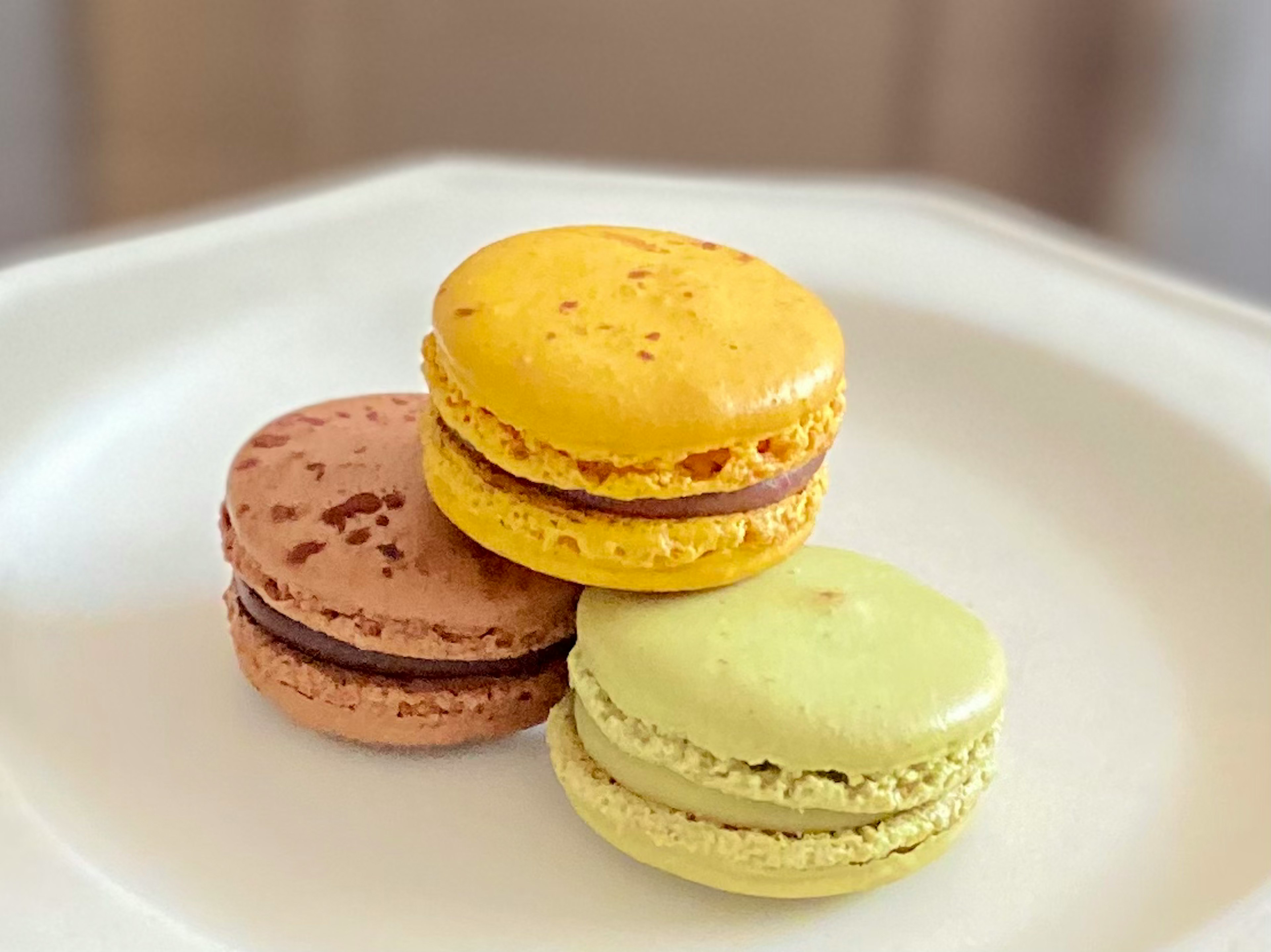 Trois macarons sur une assiette blanche