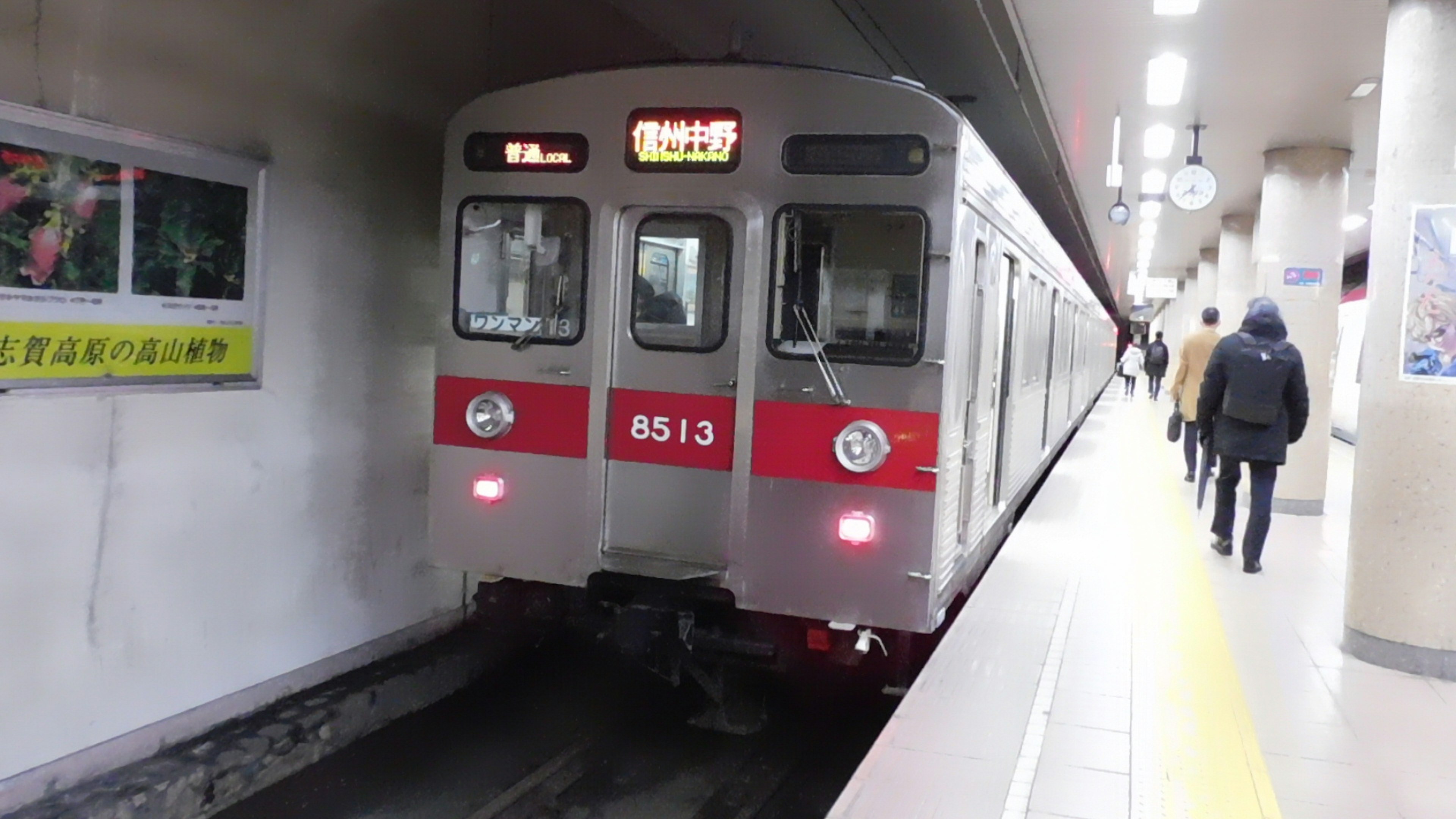 赤と銀の電車が駅に停車している様子