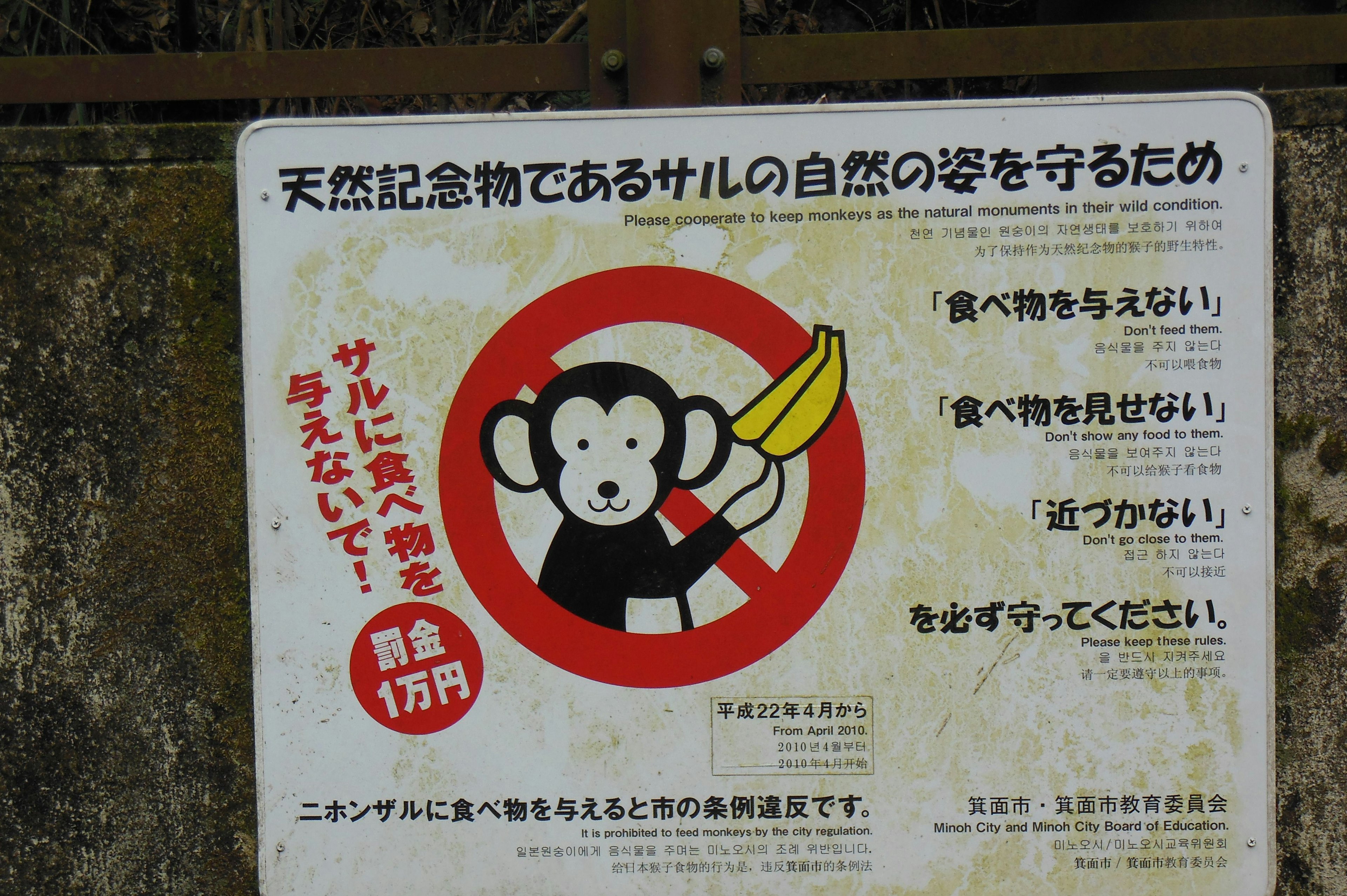 Sign with a monkey holding a banana emphasizing the importance of protecting nature