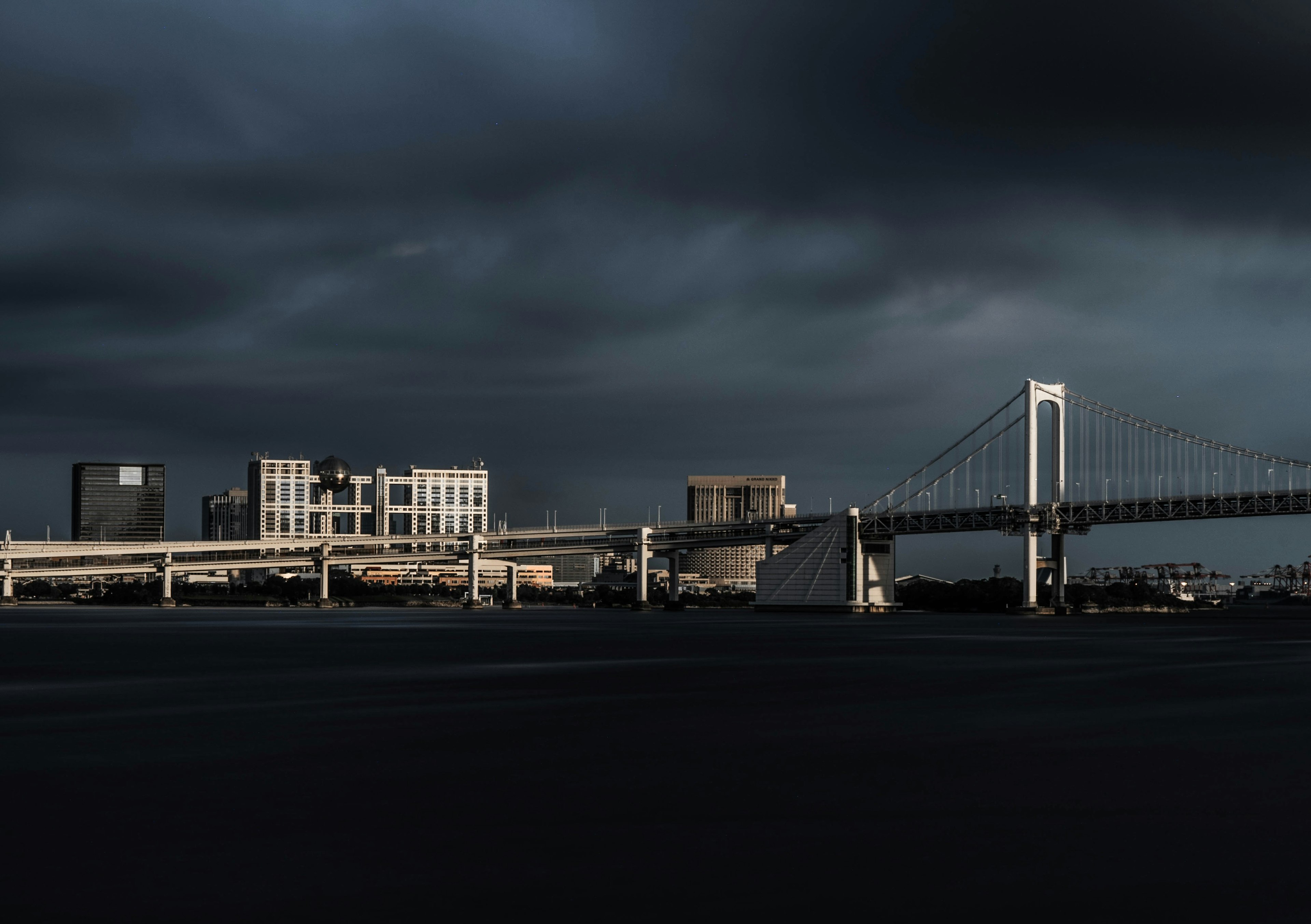 Rainbow Bridge und Stadtlandschaft unter dunklen Wolken