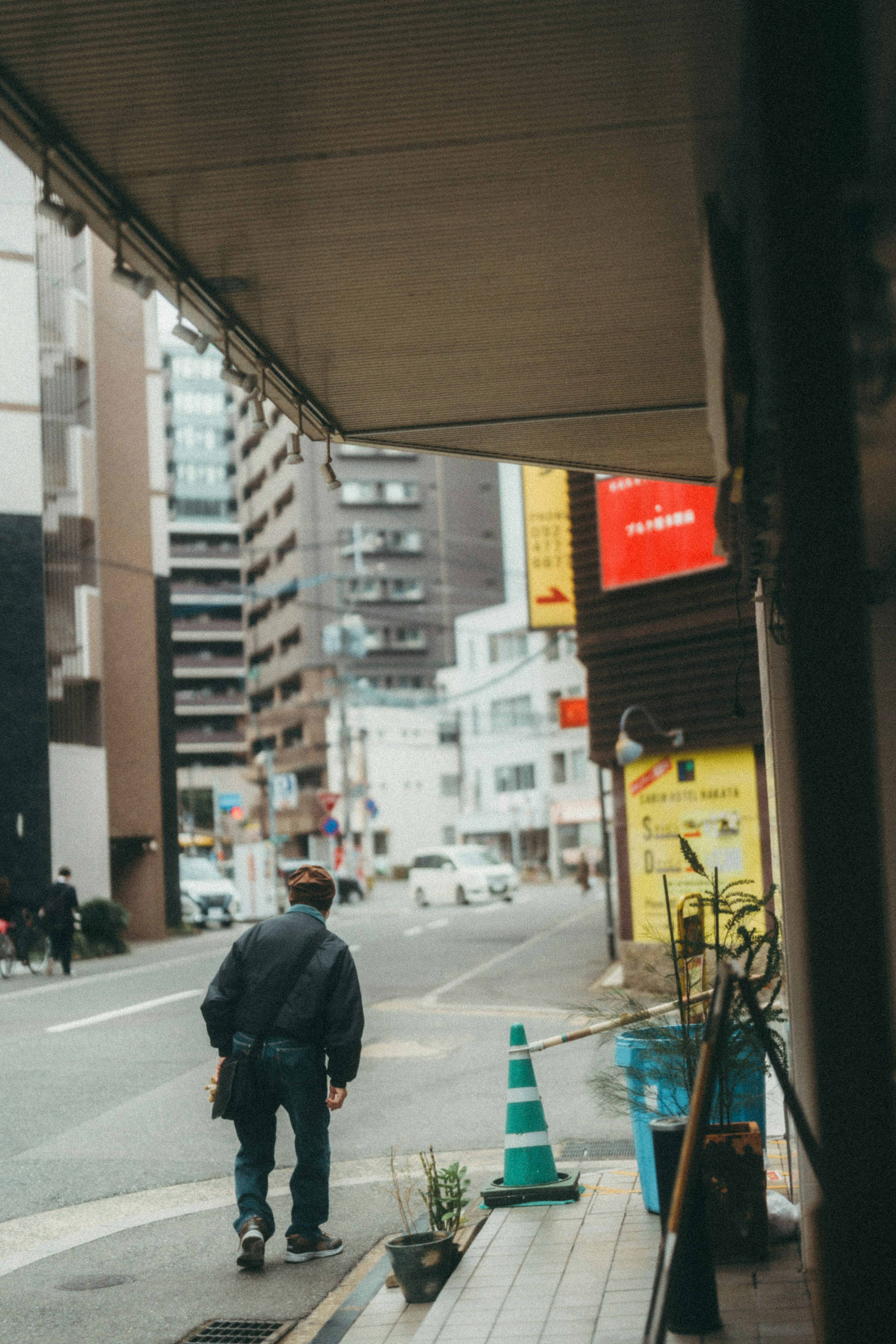 A man walking down a street surrounded by buildings