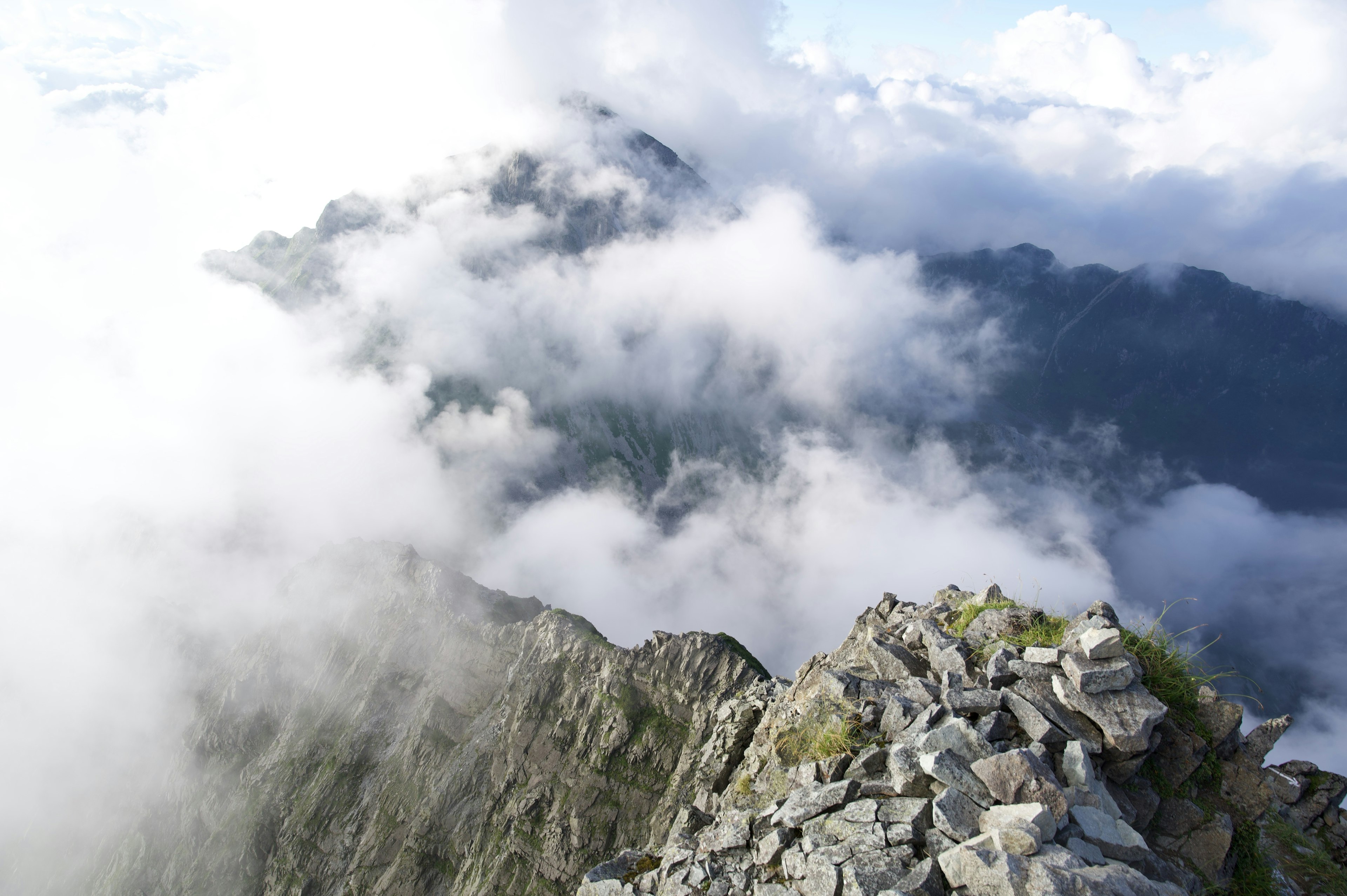 Vue d'un sommet montagneux rocheux entouré de nuages