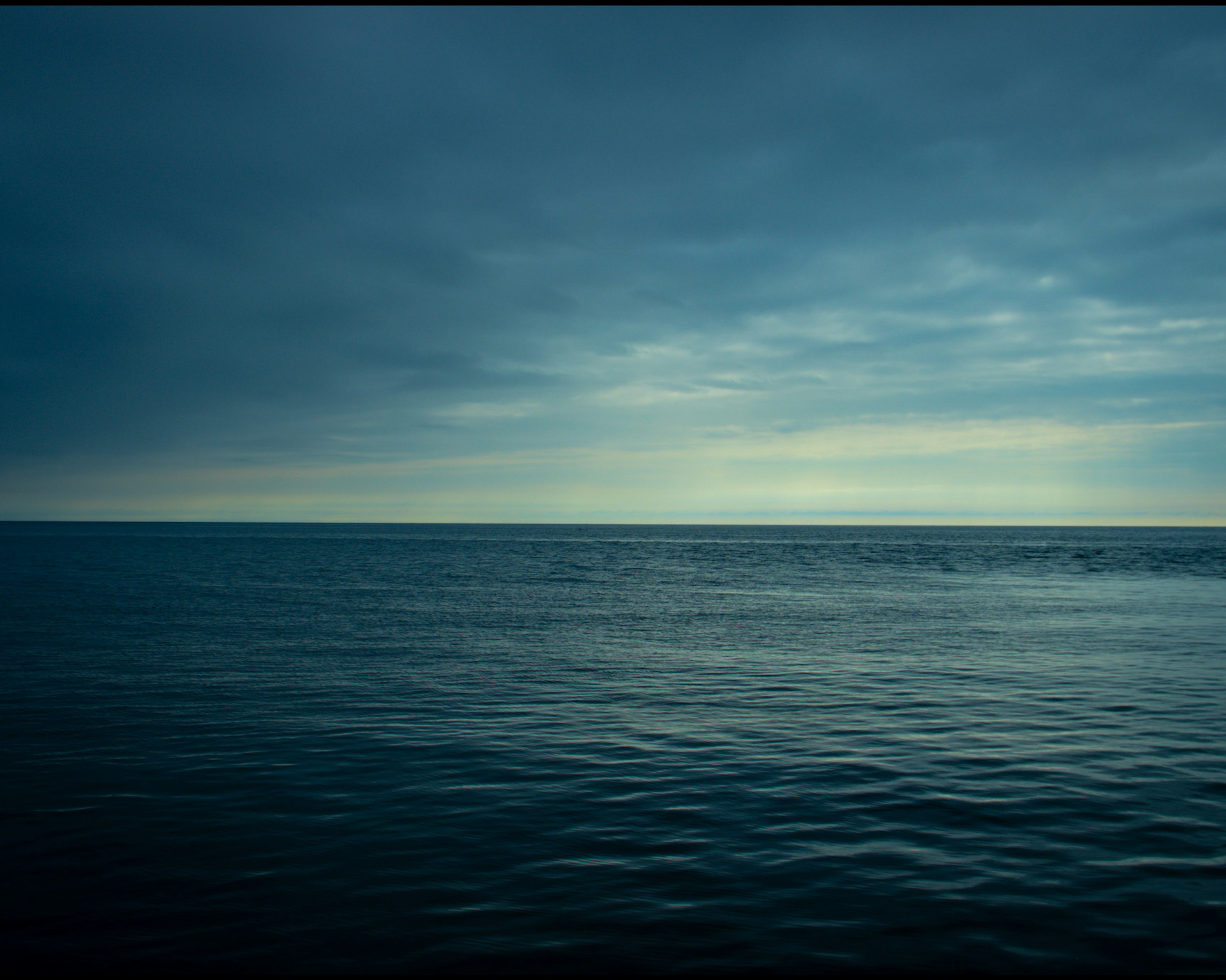 Calm sea under a cloudy sky